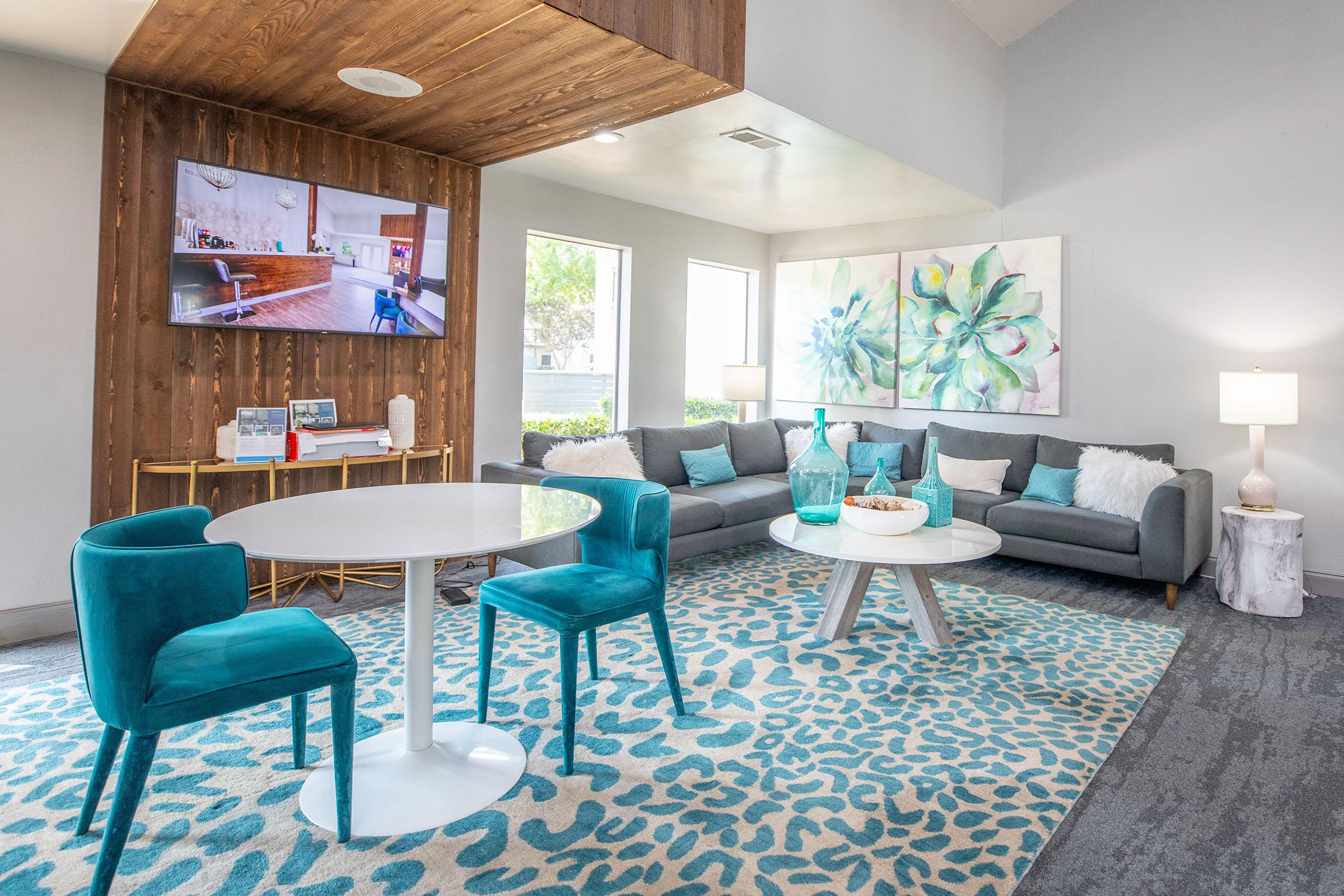 The Rise North Arlington clubhouse with colorful seating and a TV.