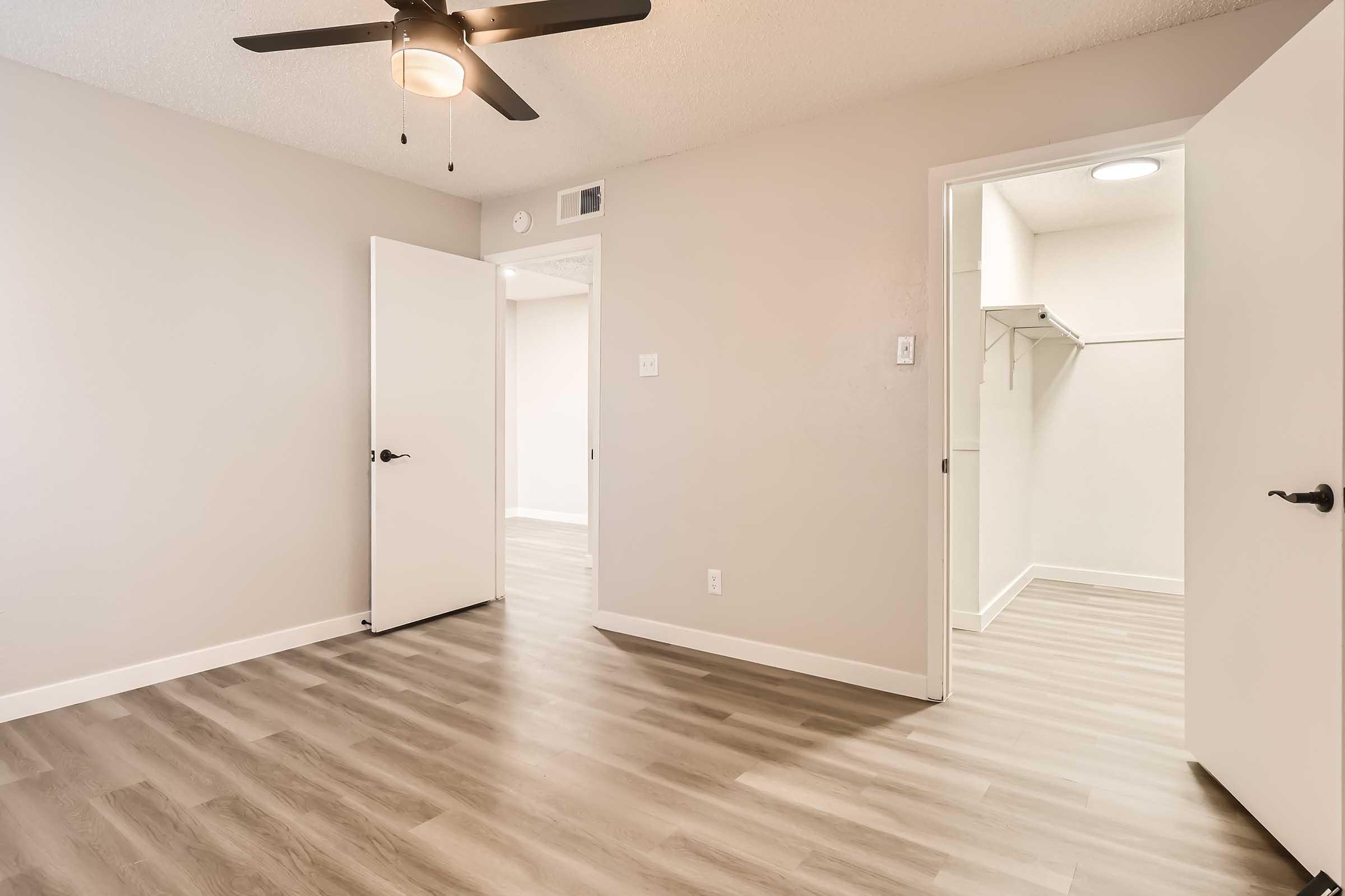 An apartment bedroom with wood-style flooring and a large closet at Rise North Arlington.