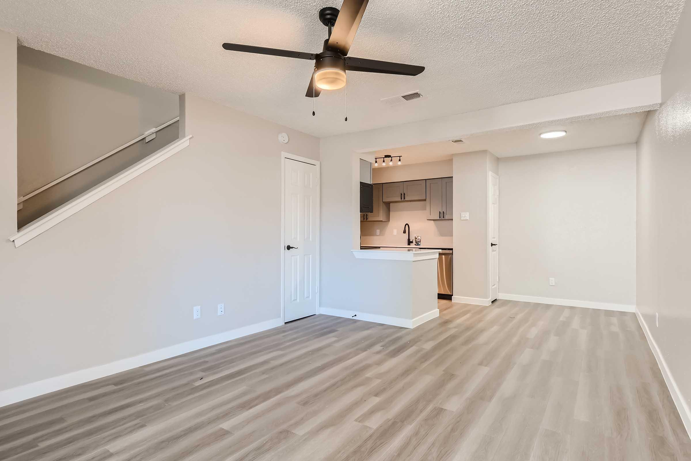 The open-concept living room with wood-style flooring and a kitchen at Rise North Arlington.