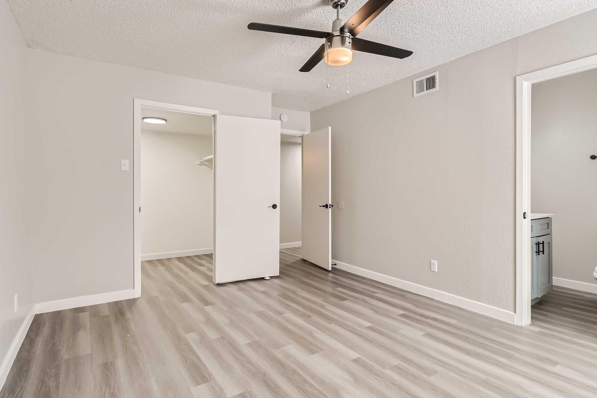 A bedroom with wood-style flooring and an en-suite bathroom at Rise North Arlington.