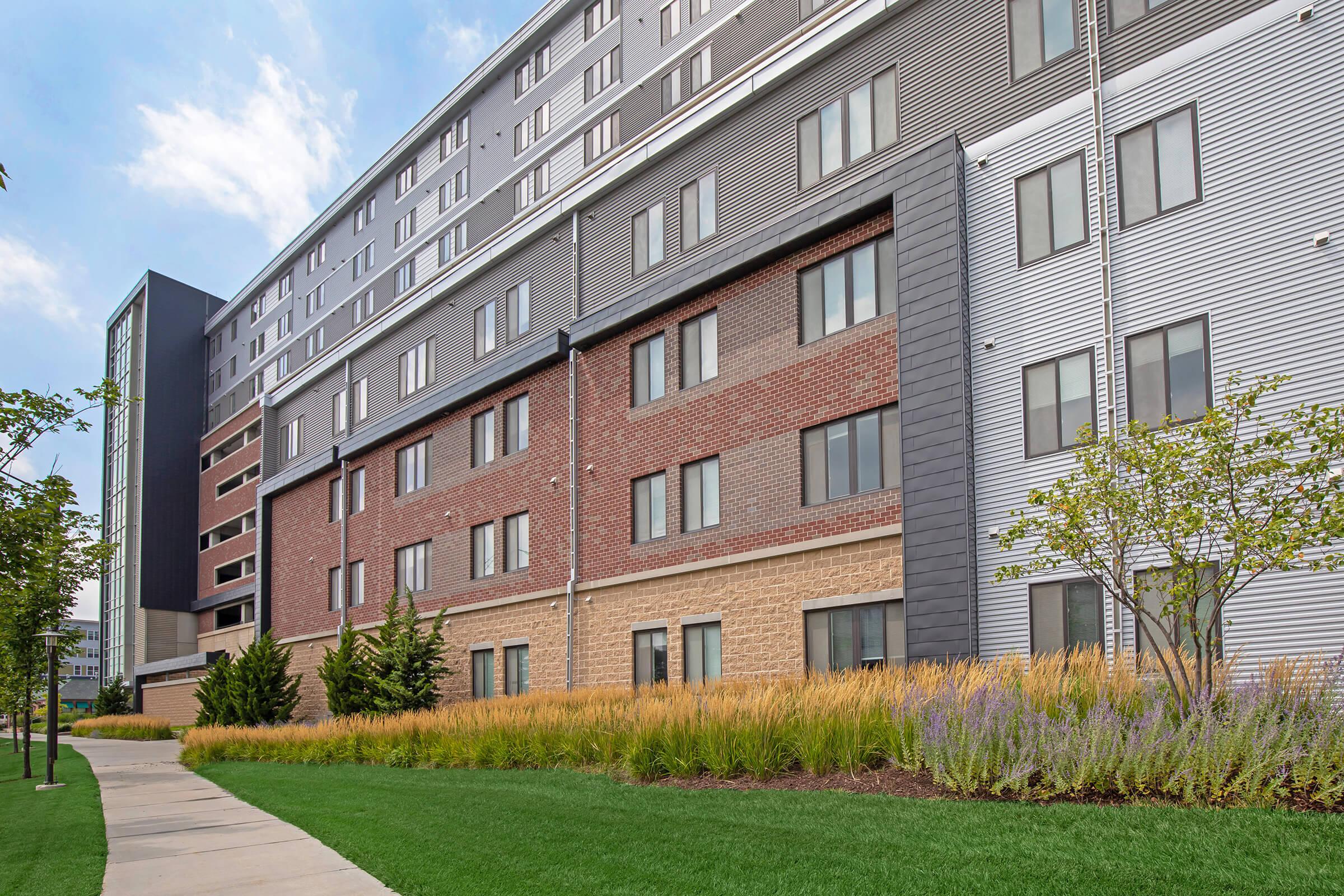 a large brick building with green grass