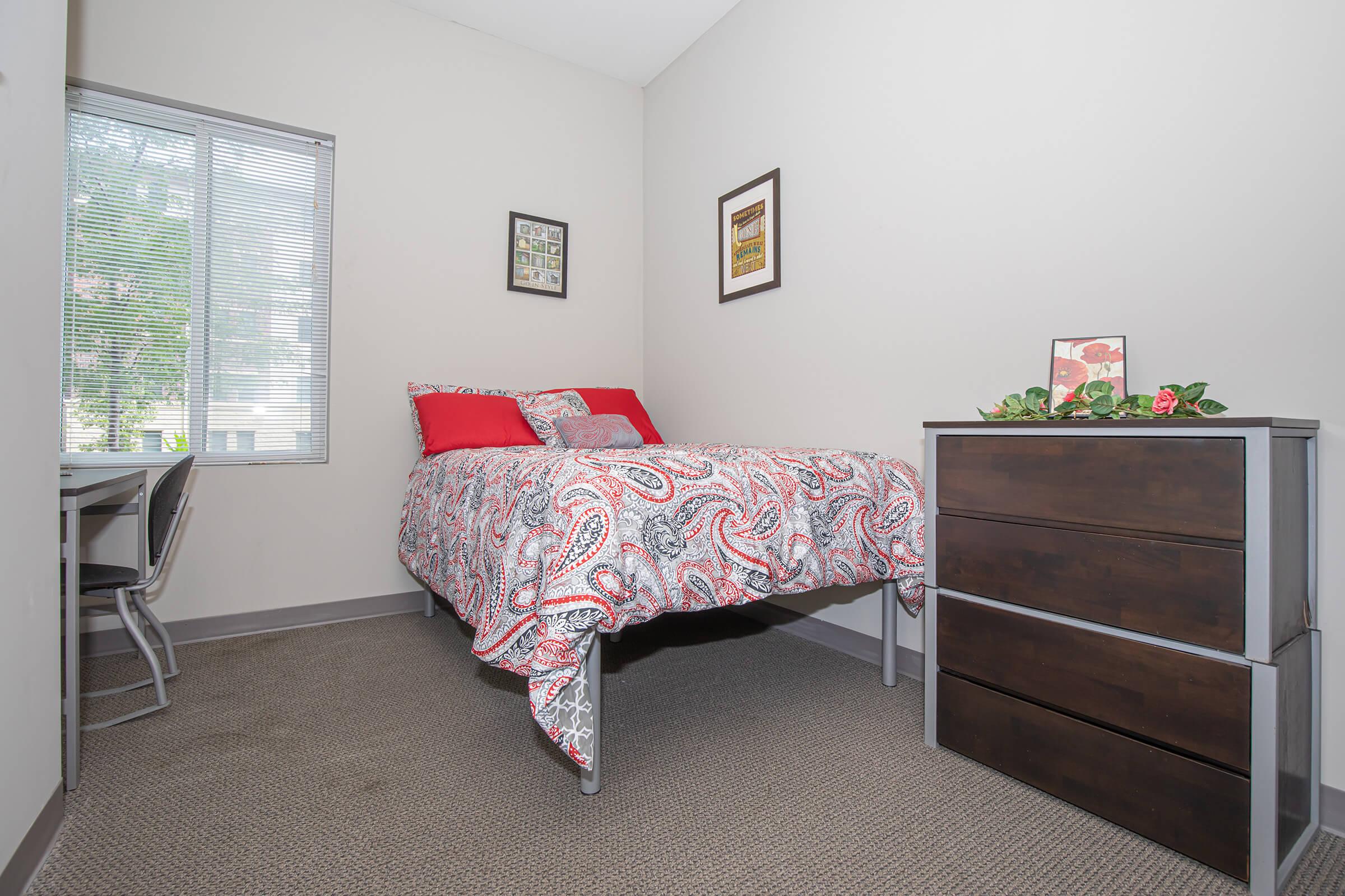 a bedroom with a bed and desk in a small room