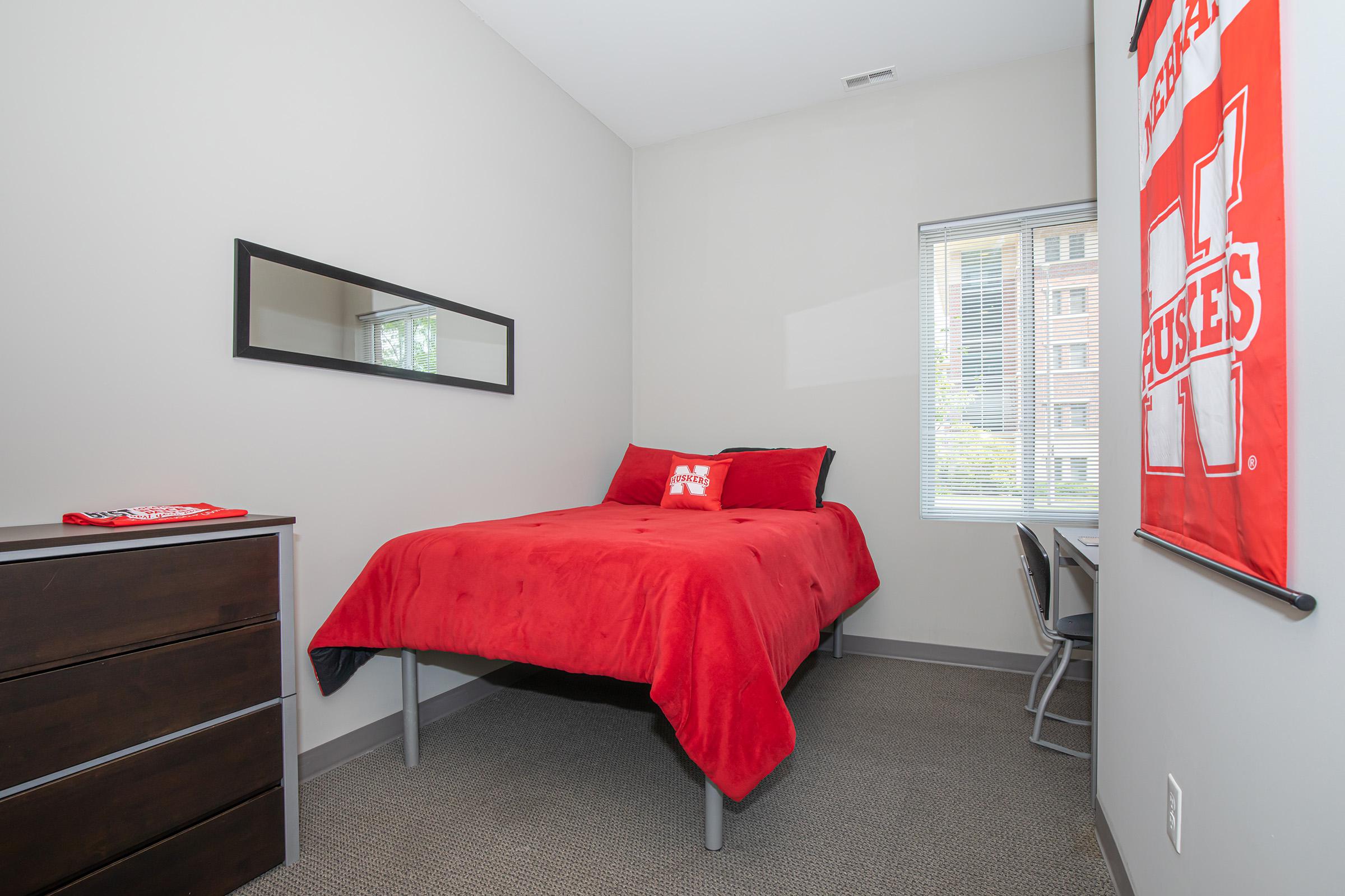 a bedroom with a bed and desk in a small room