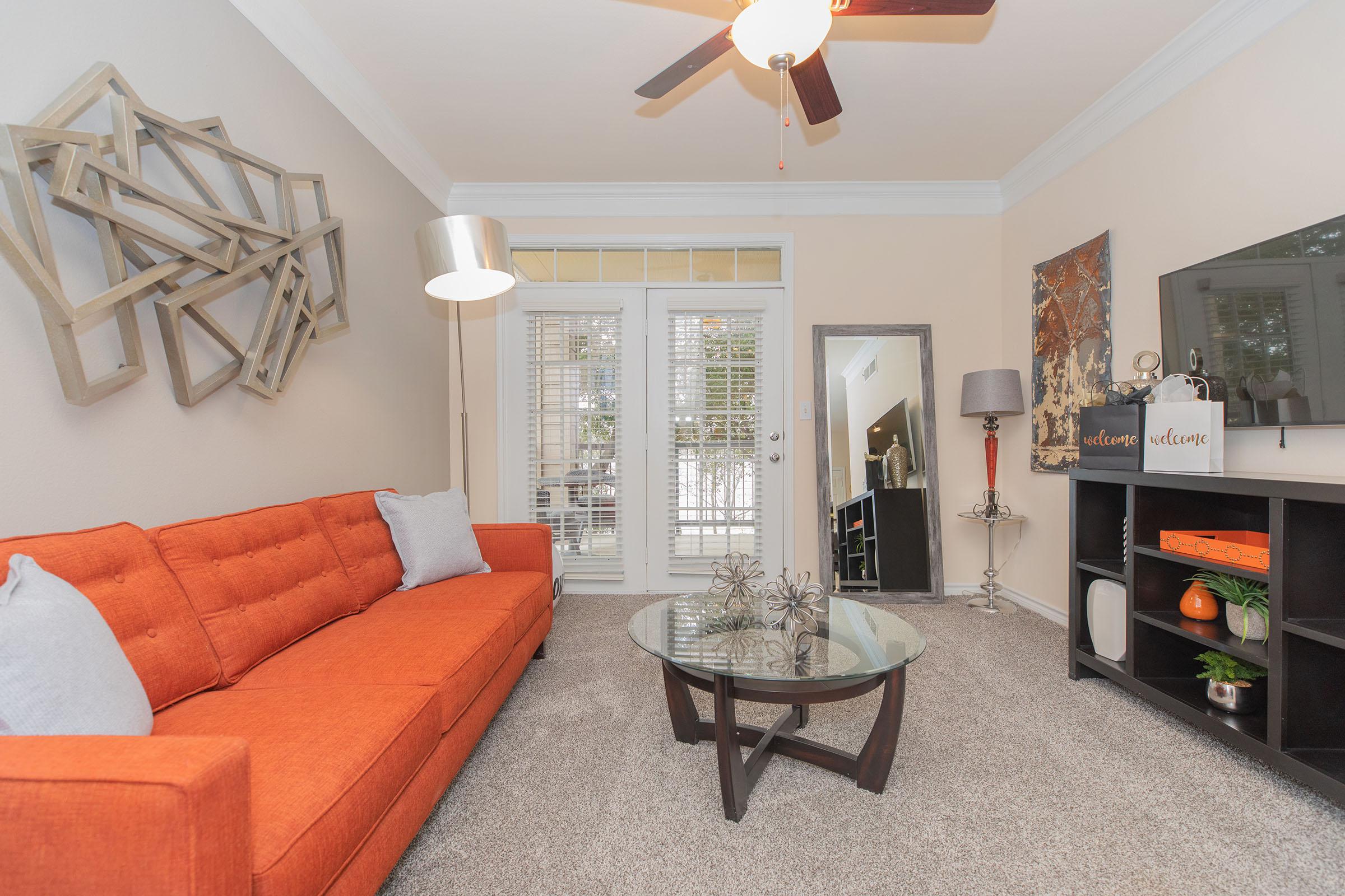 furnished carpeted living room with an orange couch