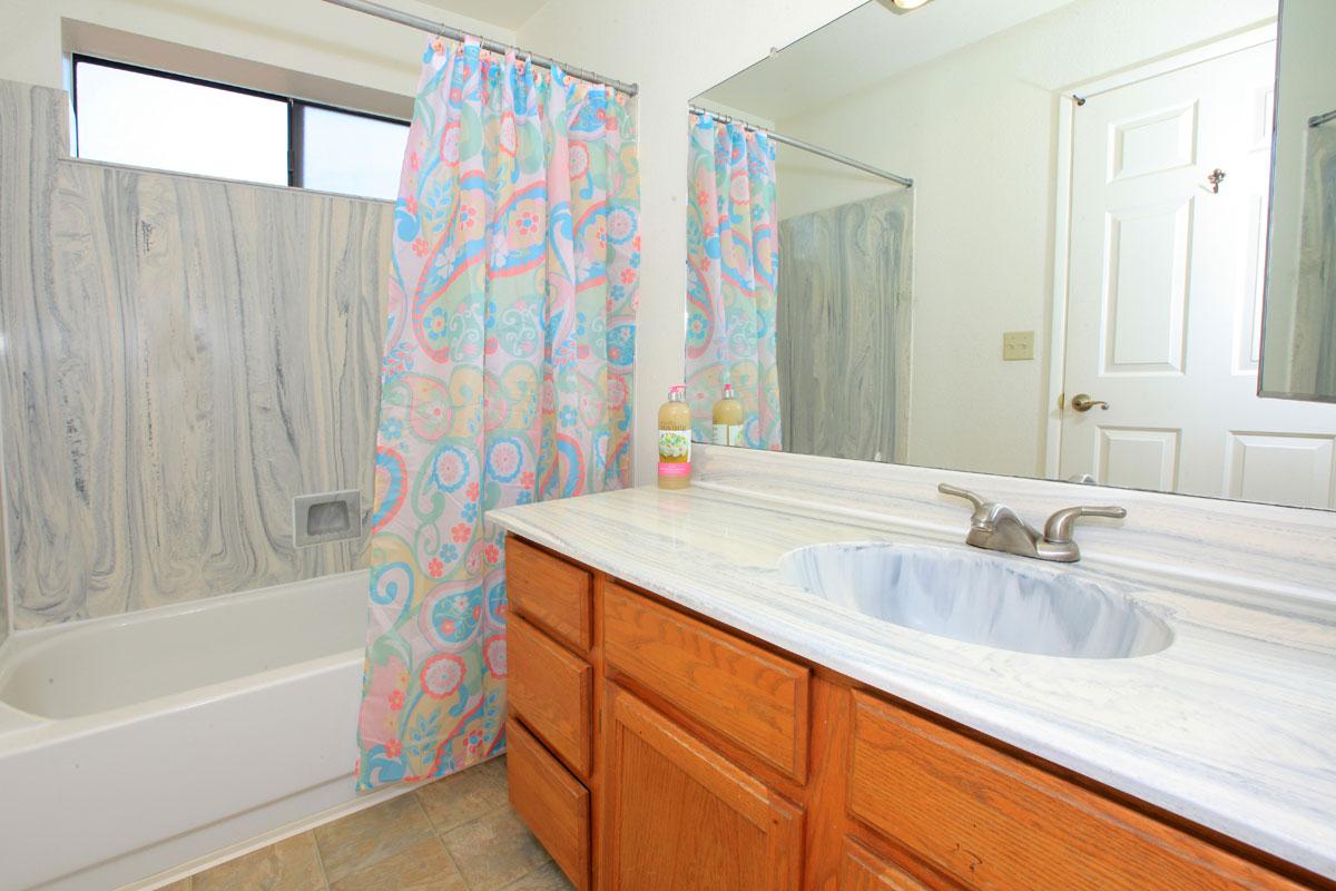 a bedroom with a large tub next to a sink