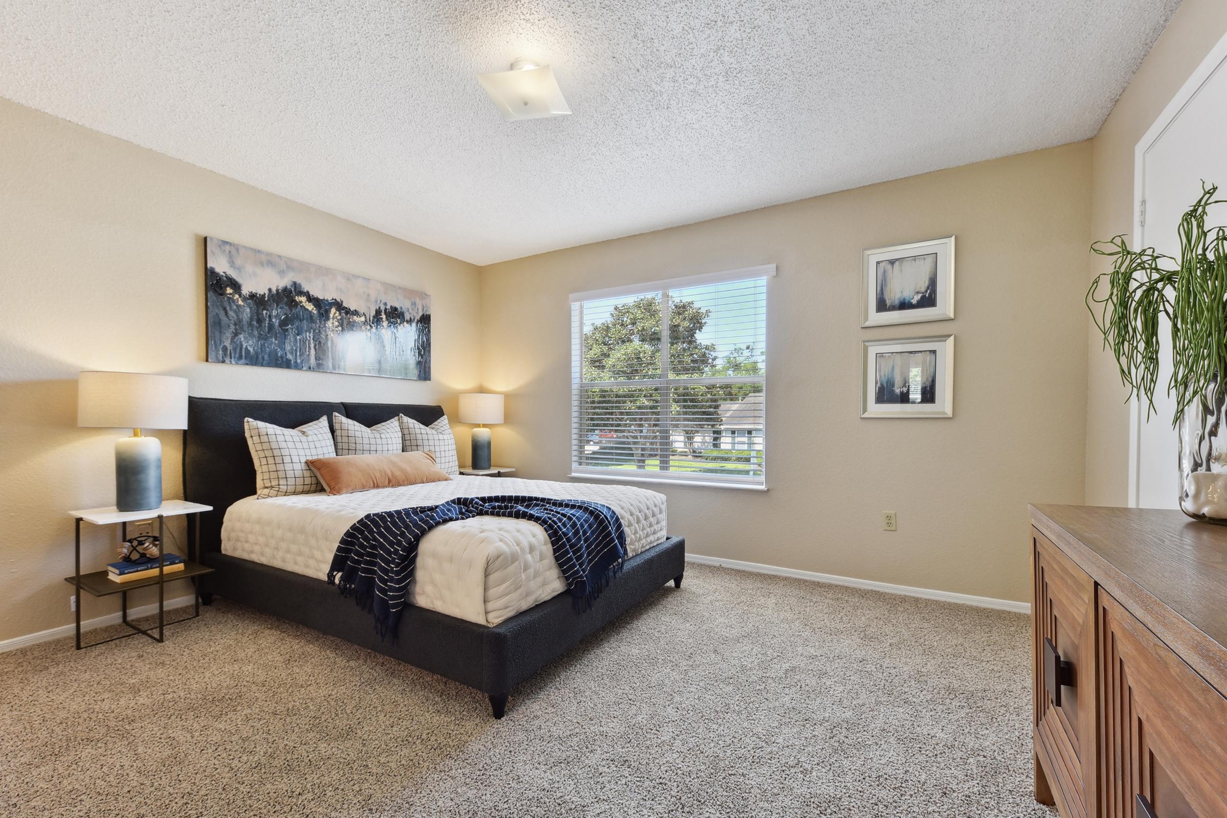 a bedroom with a bed and desk in a room