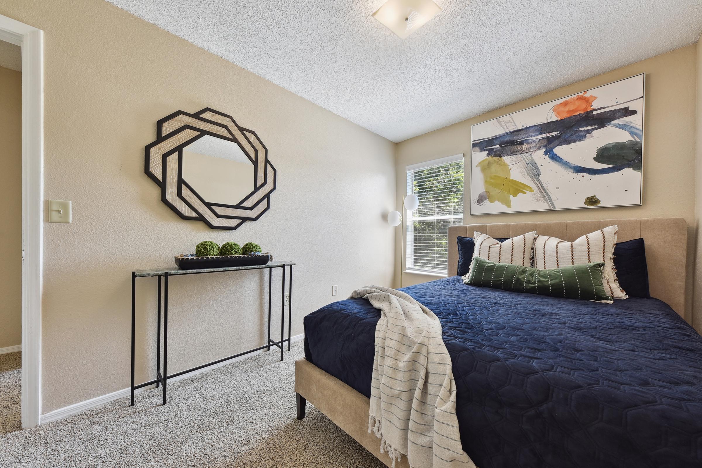 a bedroom with a bed and a painting on the wall