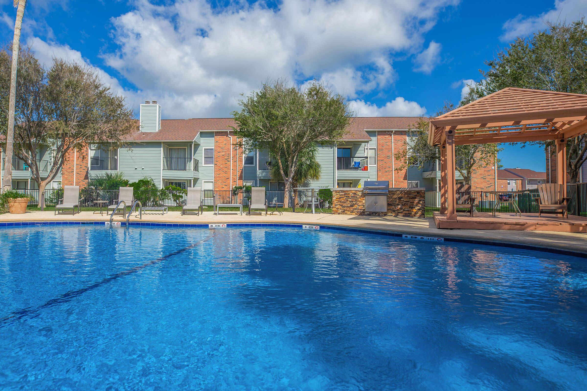 a house with a pool in front of a body of water