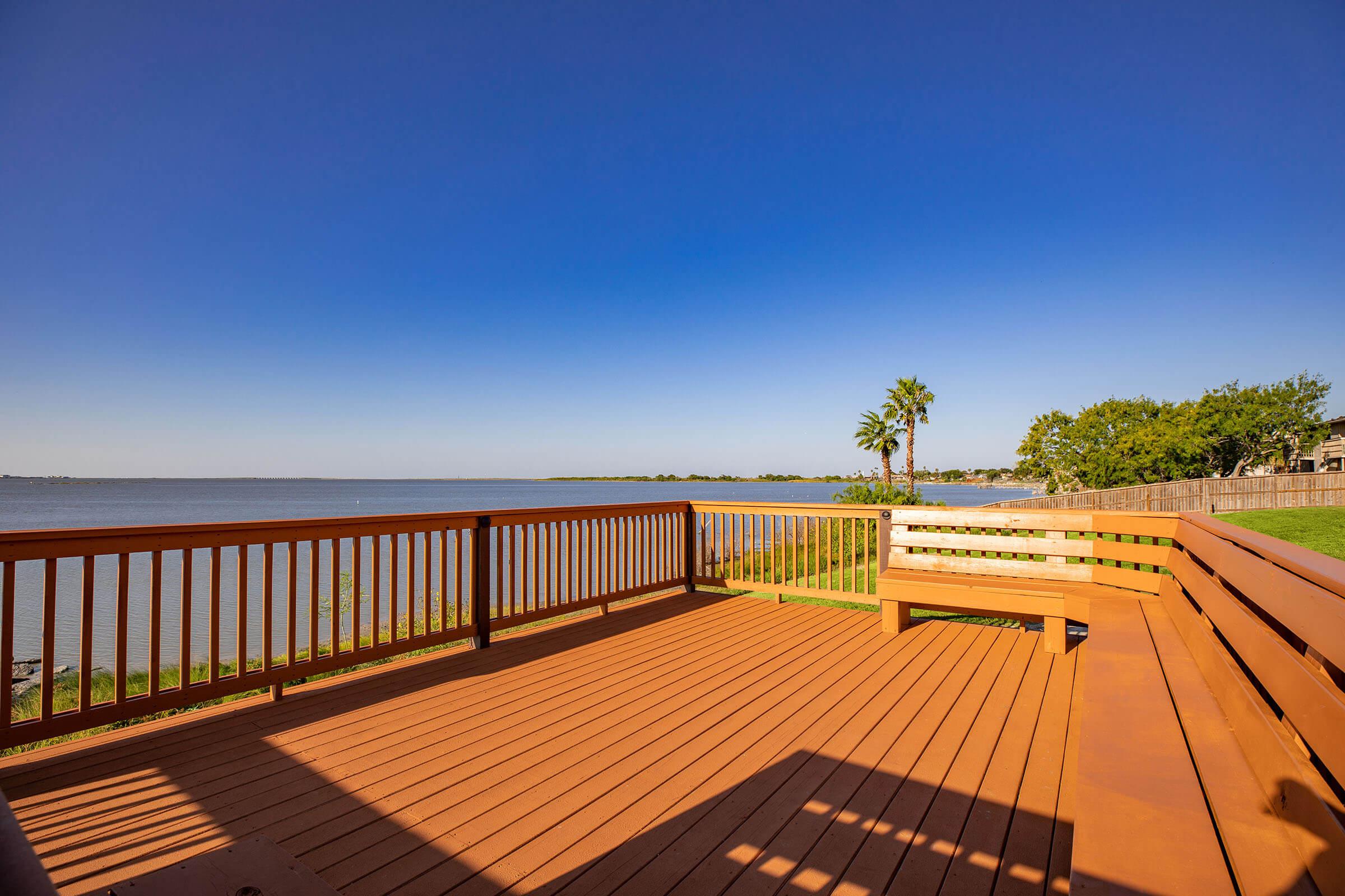 a wooden pier next to a fence