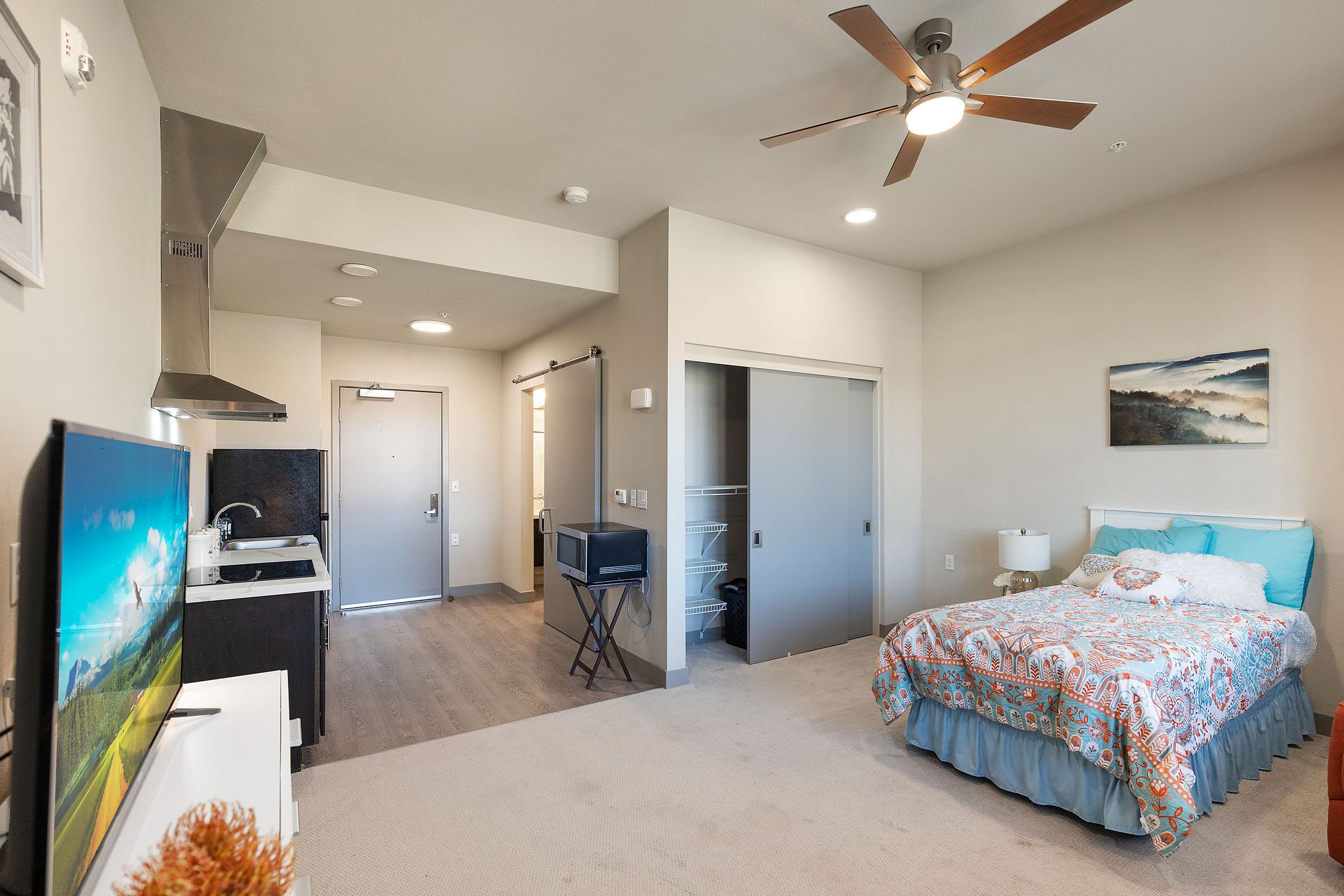 a bedroom with a bed and desk in a room