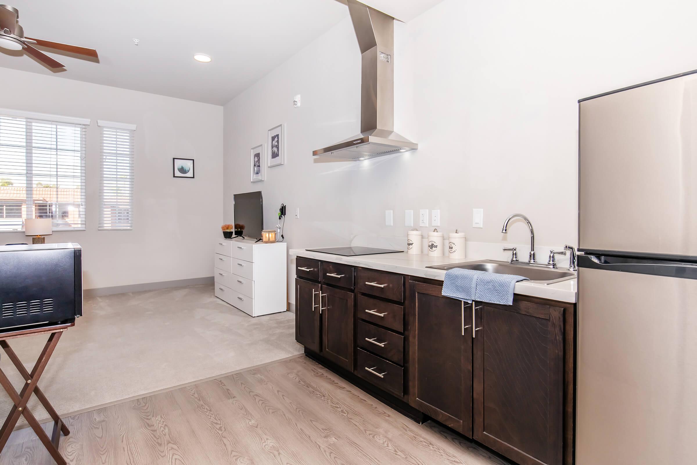 a kitchen with a sink and a mirror in a room