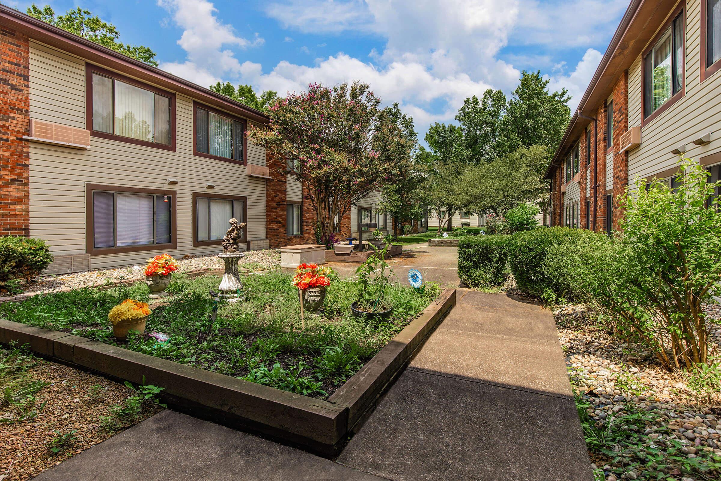 a garden in front of a brick building