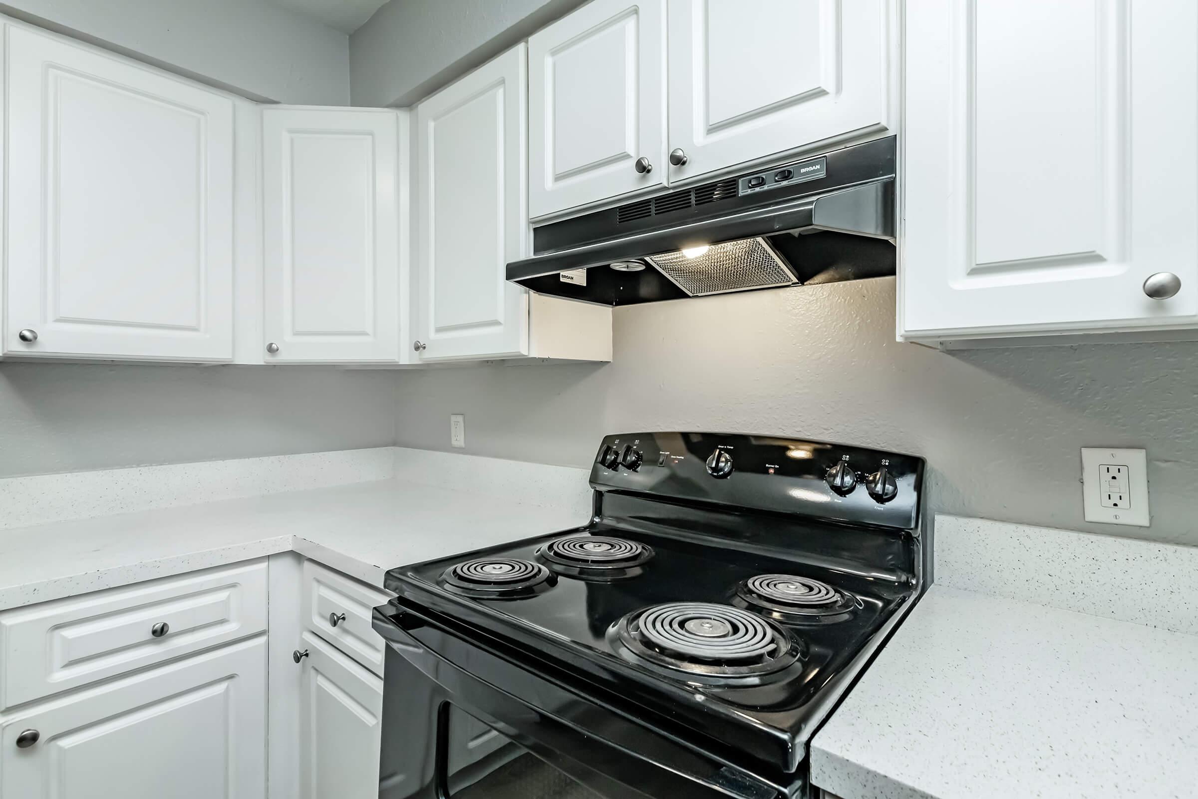 a stove top oven sitting inside of a kitchen