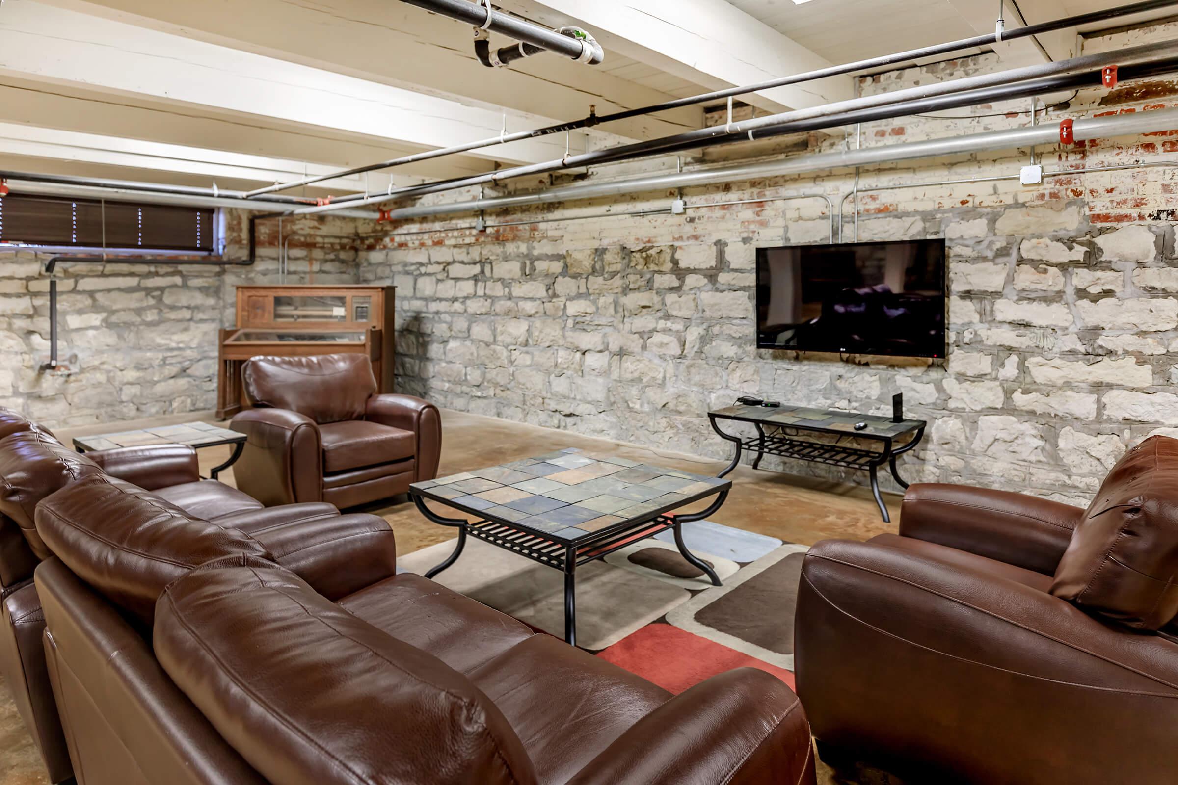 a brown leather couch in a living room filled with furniture and a fireplace