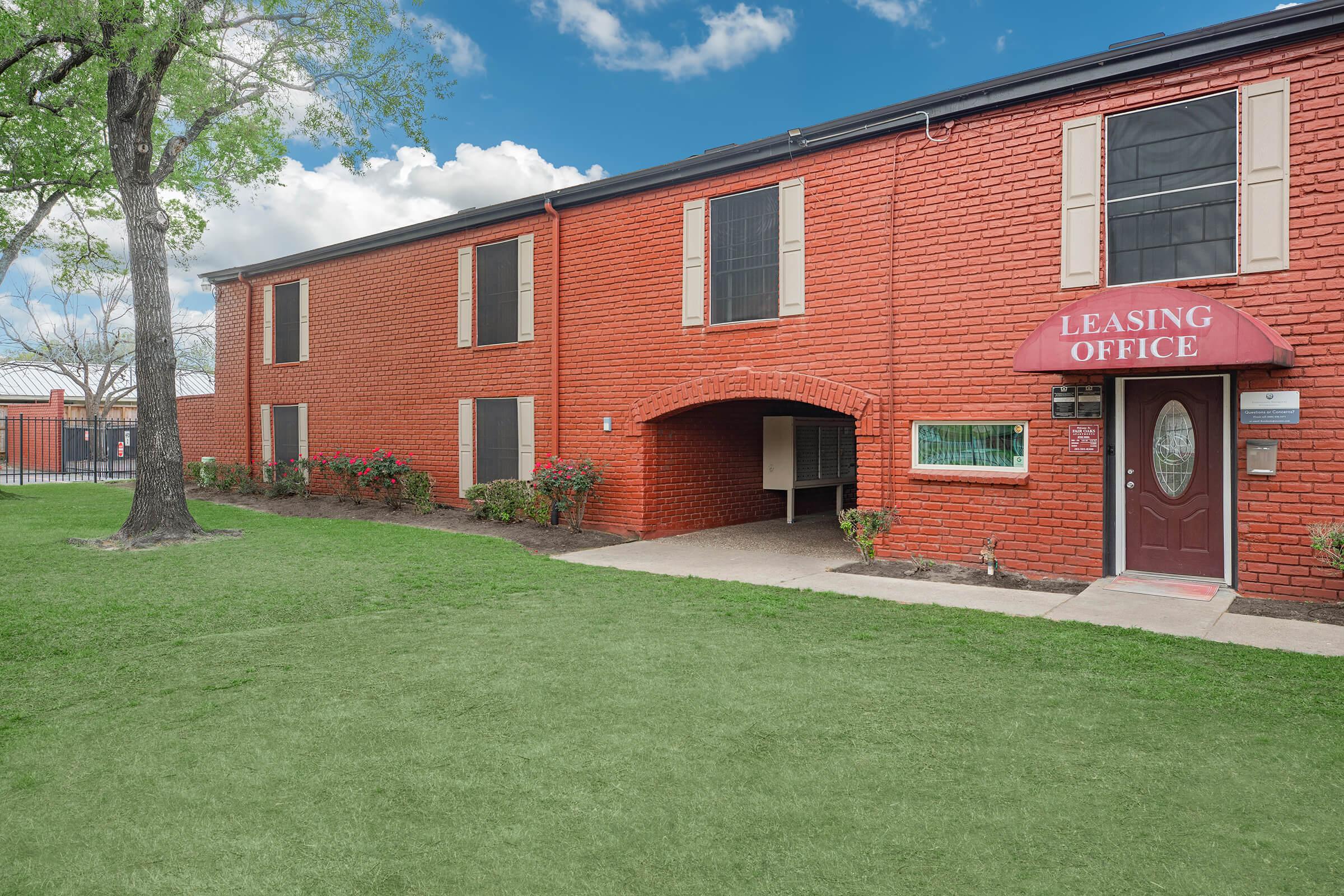 a large lawn in front of a brick building