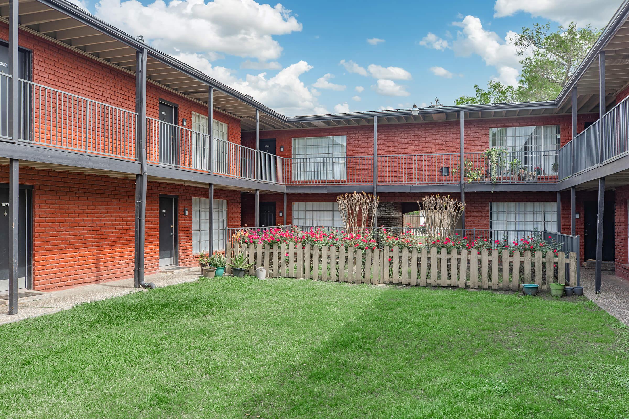 a large lawn in front of a brick building