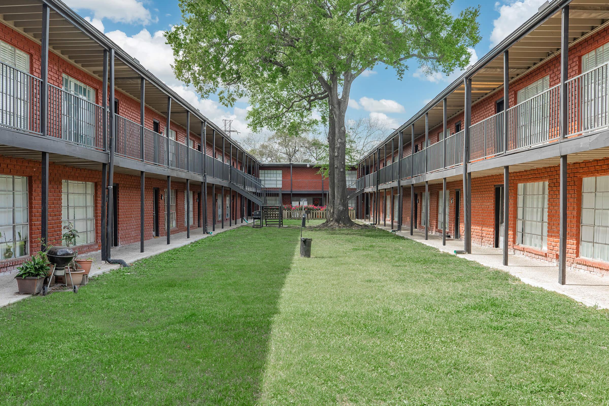 a large lawn in front of a brick building