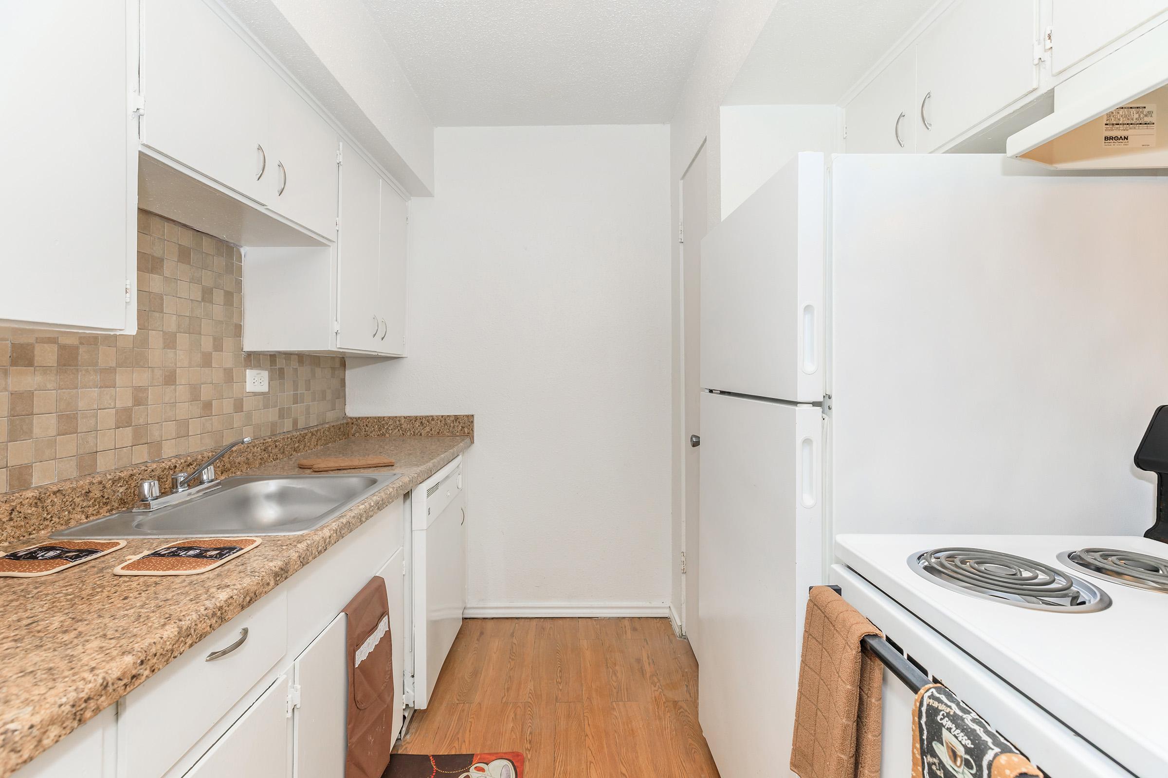 a kitchen with a stove sink and refrigerator