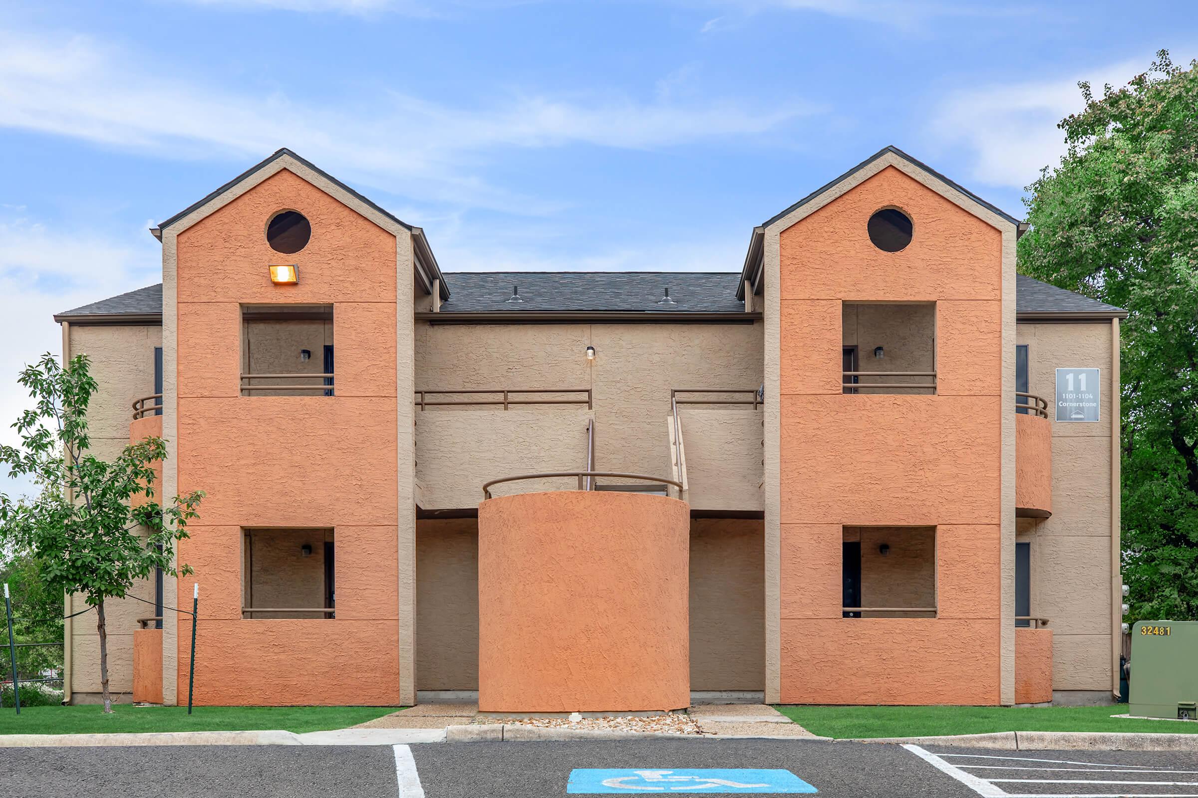 a large brick building with grass in front of a house