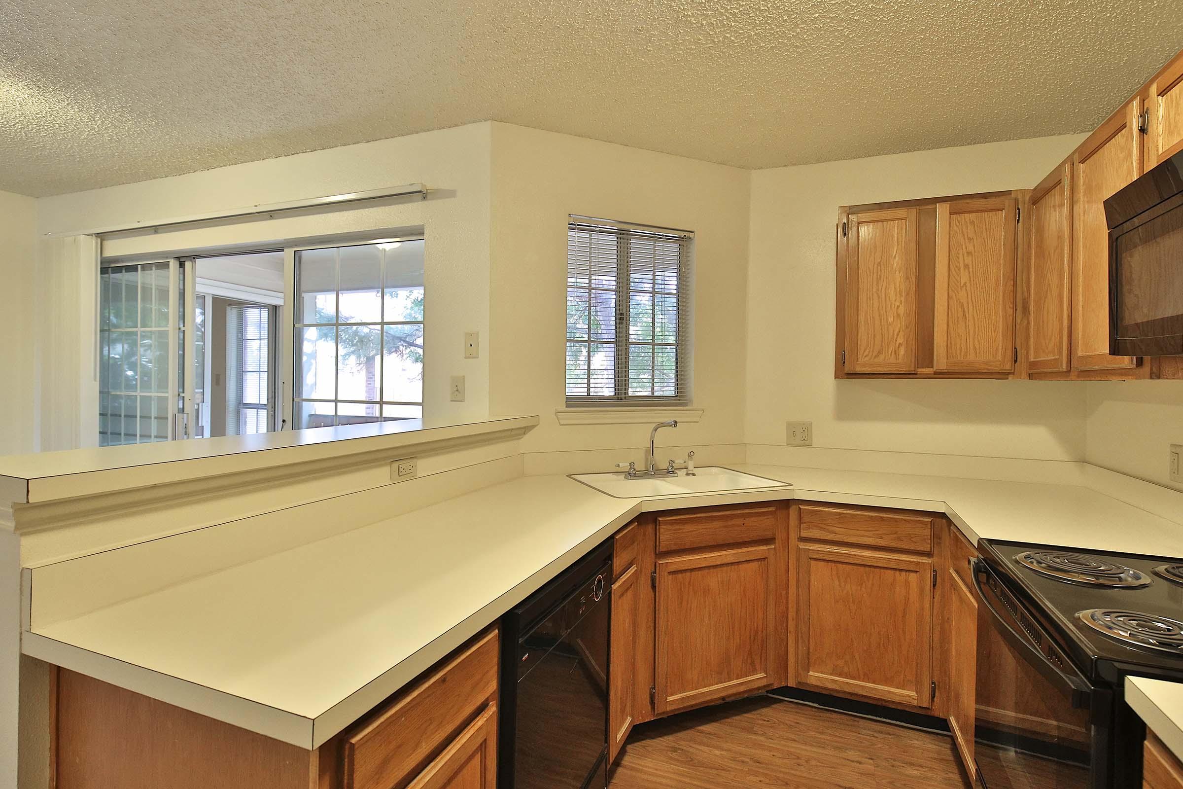 a kitchen with wooden cabinets and a window
