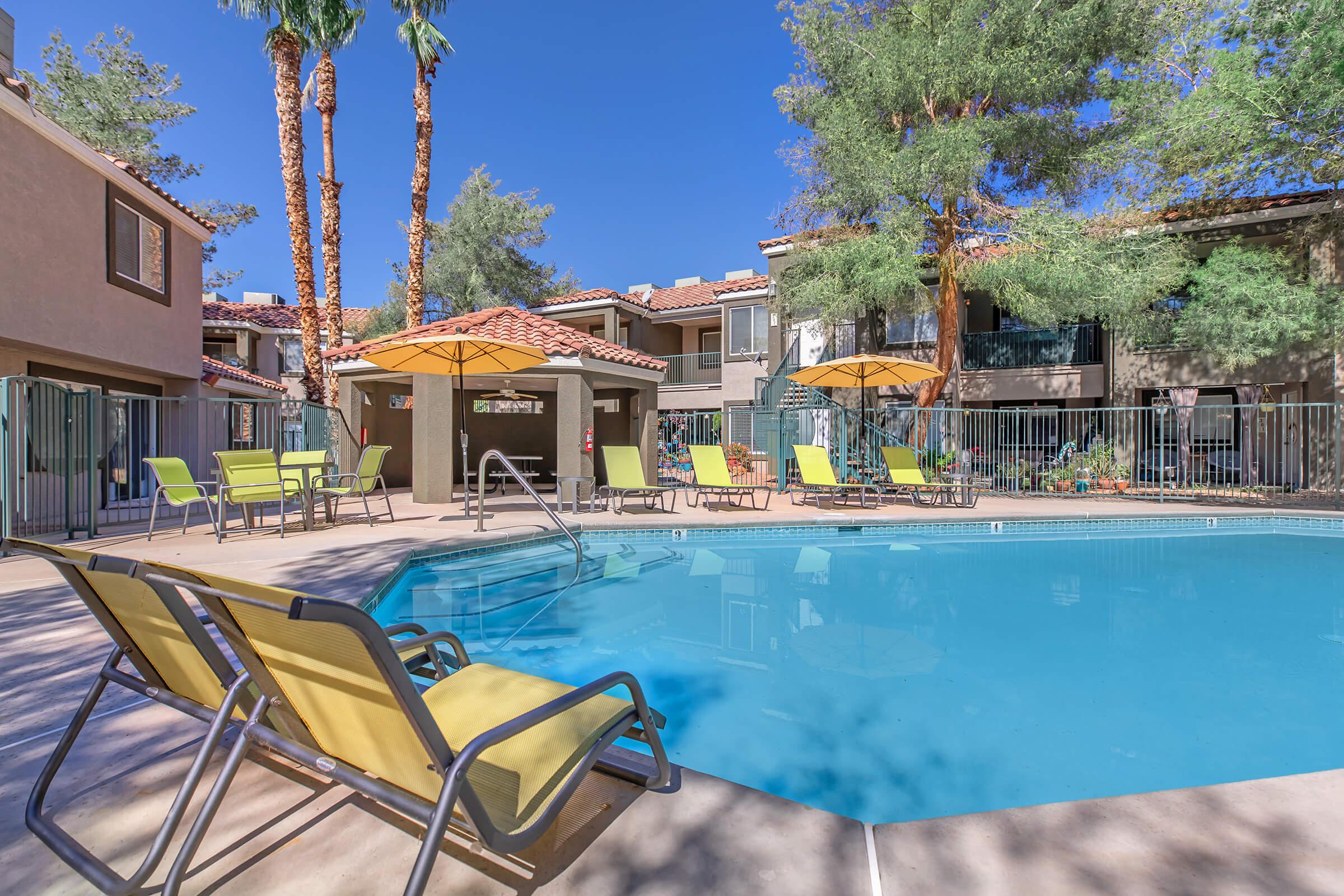 a row of lawn chairs sitting next to a pool of water