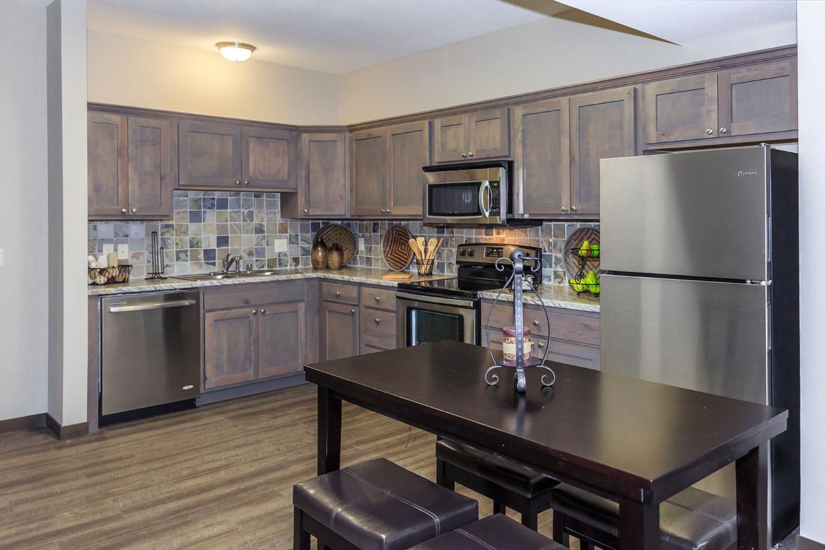 a modern kitchen with stainless steel appliances and wooden cabinets