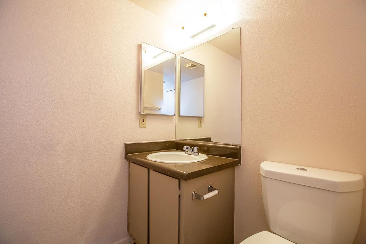 a white sink sitting under a mirror