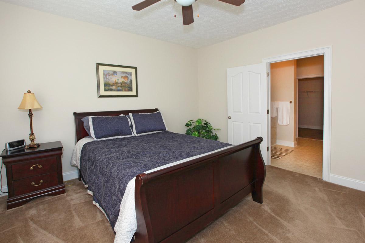 a bedroom with a bed and desk in a small room