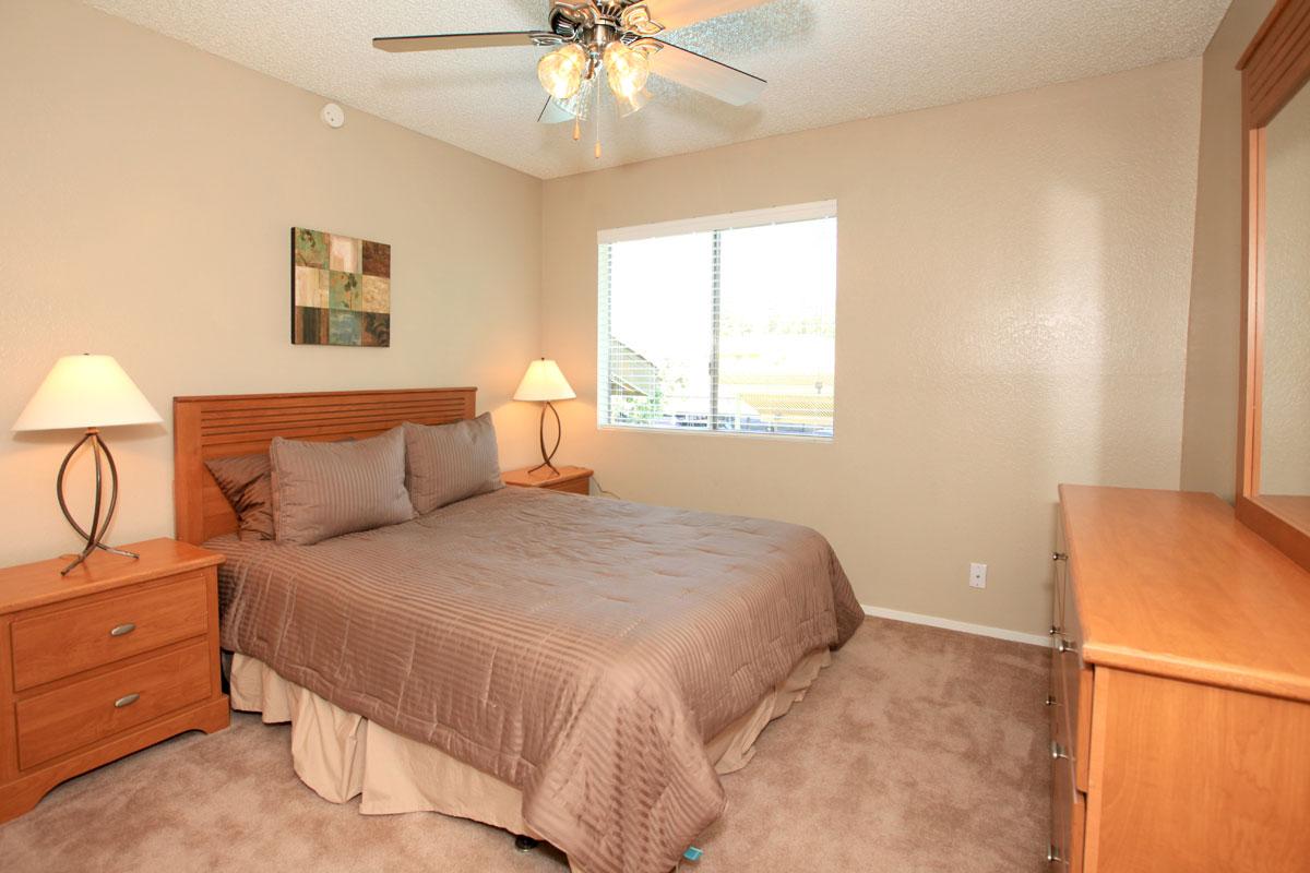 a bedroom with a bed and desk in a room