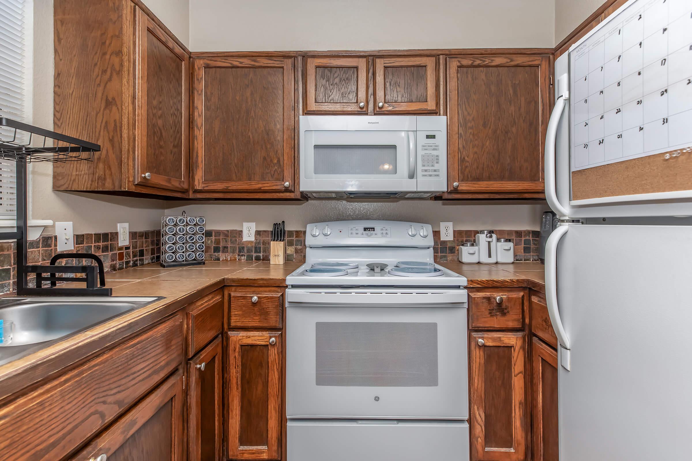 a stove top oven sitting inside of a kitchen