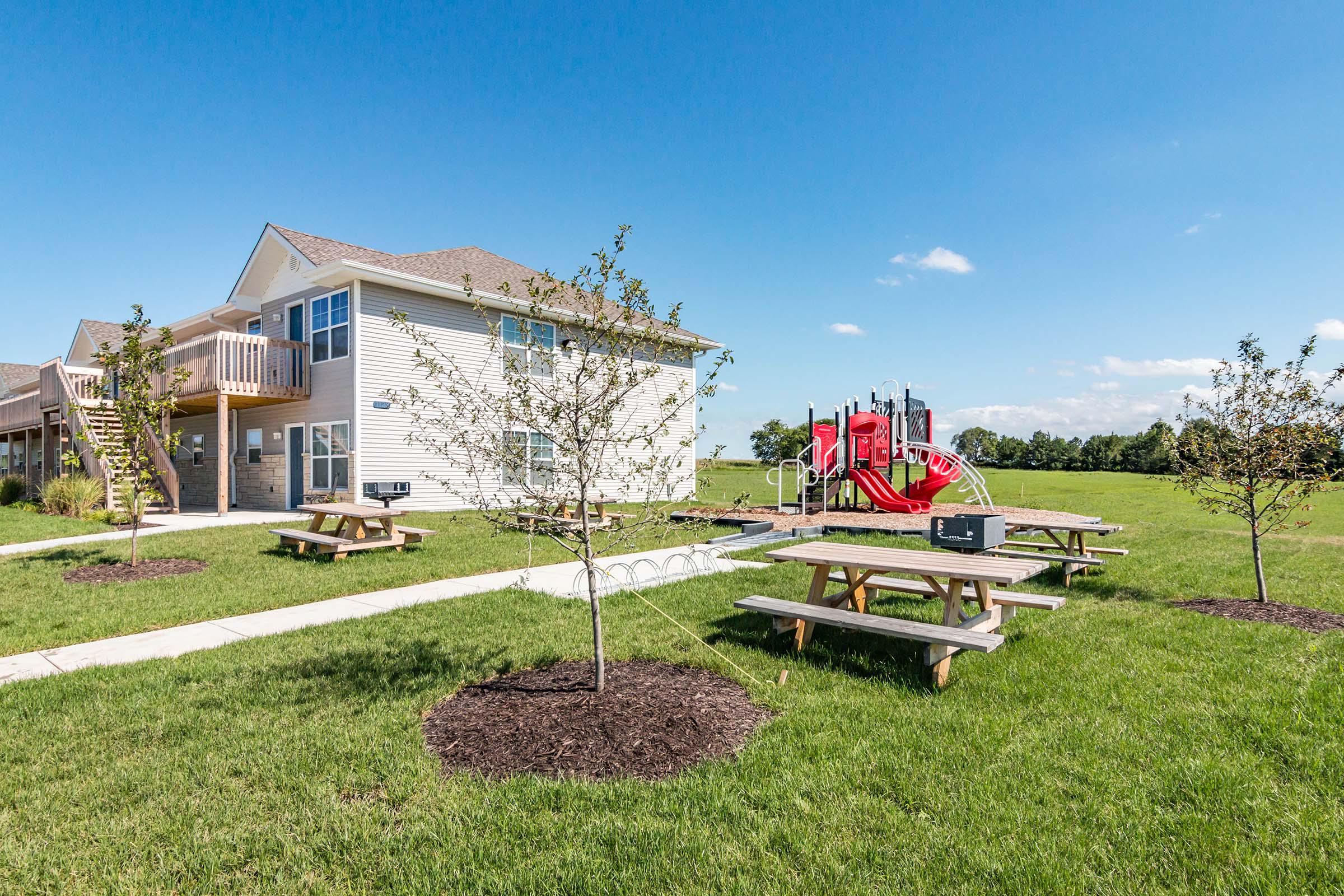 a group of lawn chairs sitting on top of a grass covered field