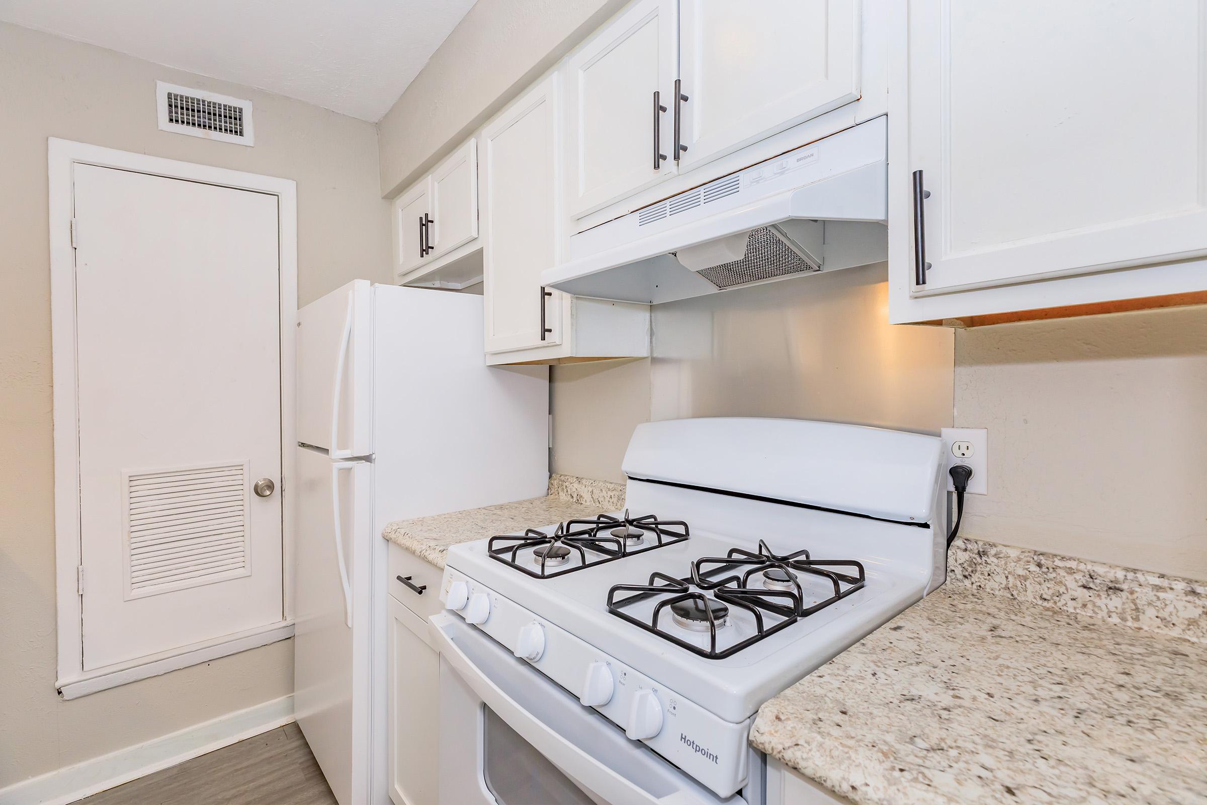 a stove top oven sitting inside of a kitchen