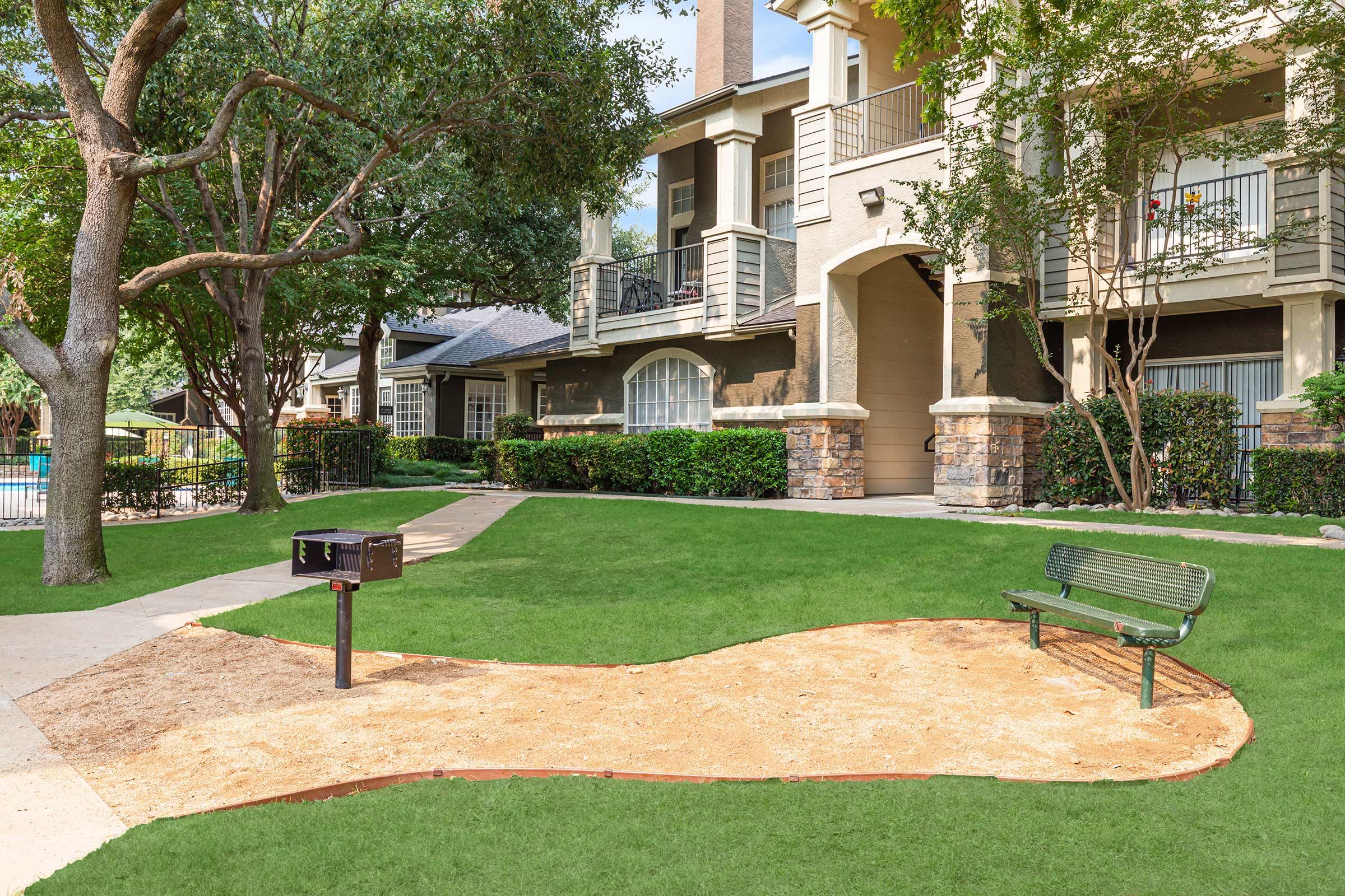 a barbecue and bench with green grass