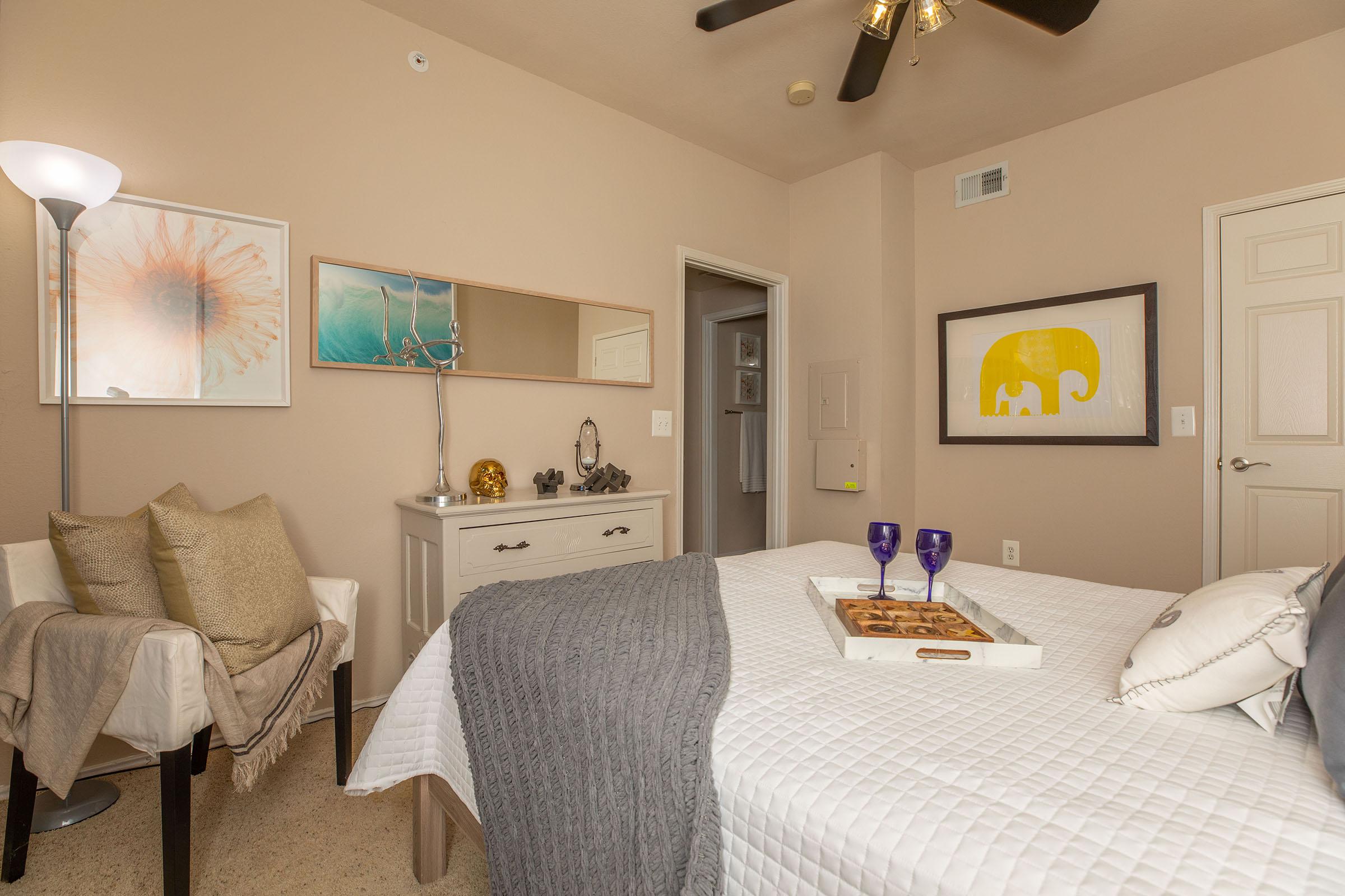 a furnished bedroom with a tan dresser