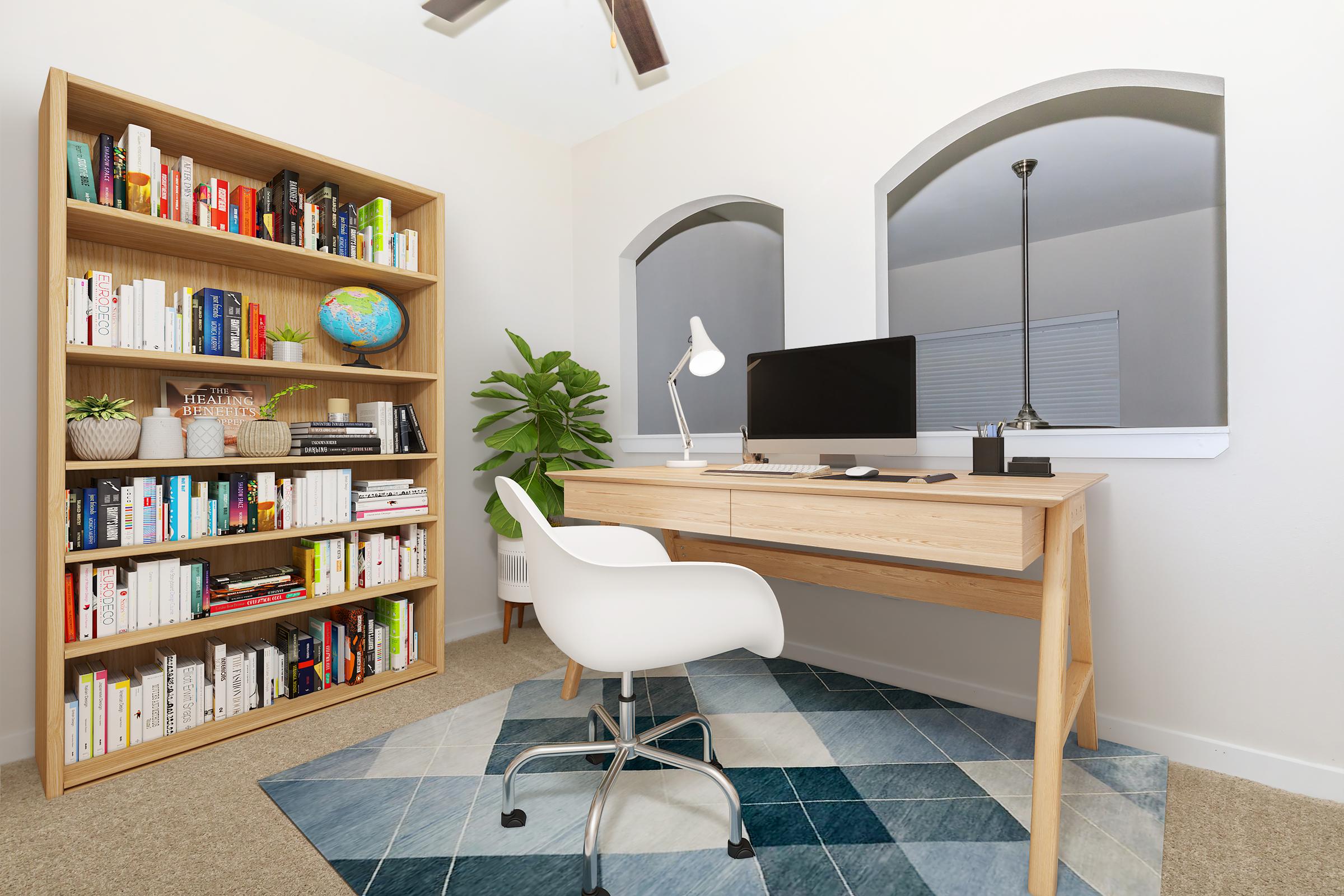 Modern home office setup featuring a wooden desk with a computer and desk lamp. A white chair is positioned at the desk. In the background, a tall bookshelf filled with books and a globe, alongside a potted plant. Two arched windows contribute to the bright, inviting atmosphere, with a stylish area rug on the floor.