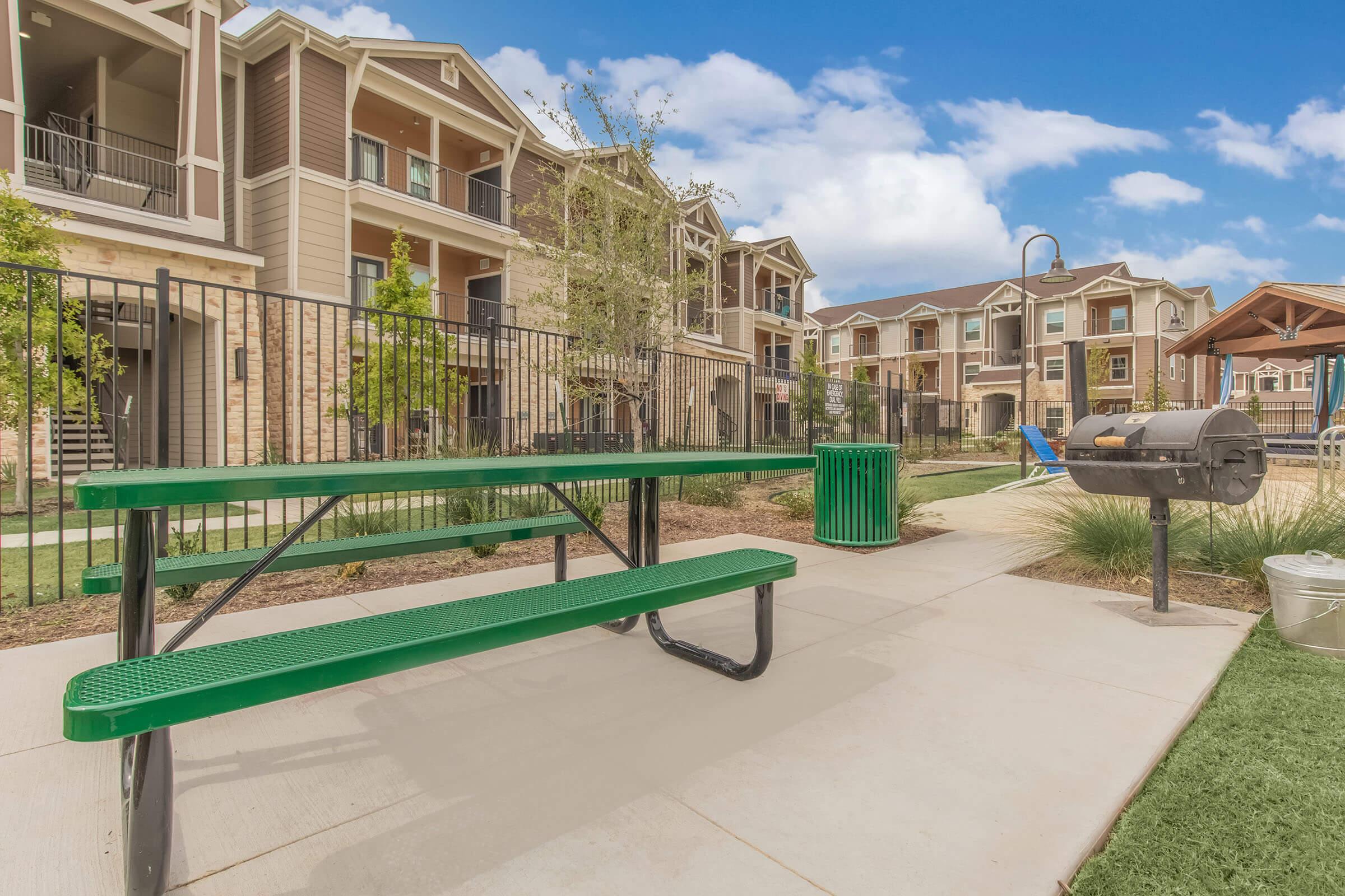 a green bench sitting in front of a building