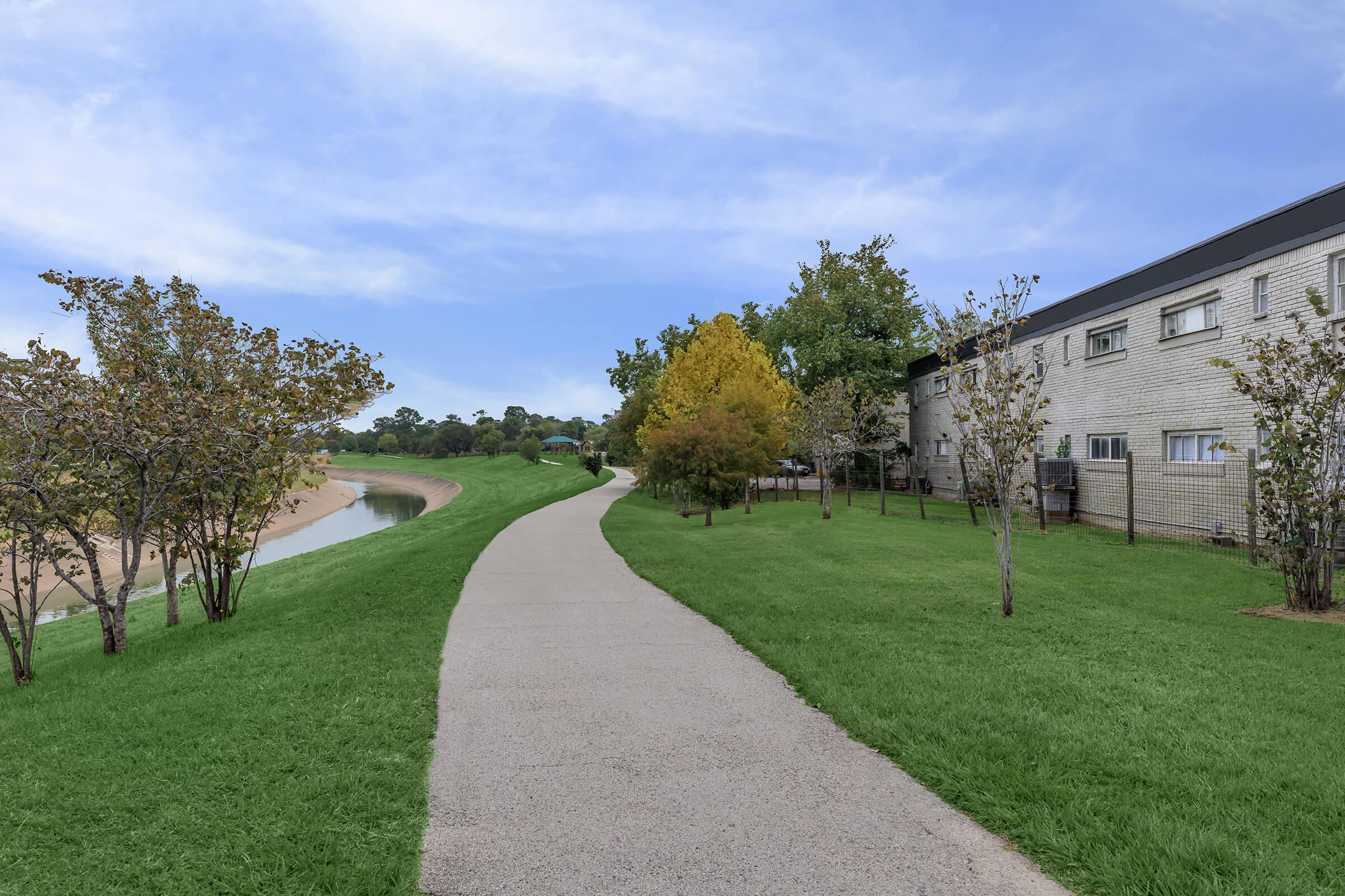 a path with grass in front of a building