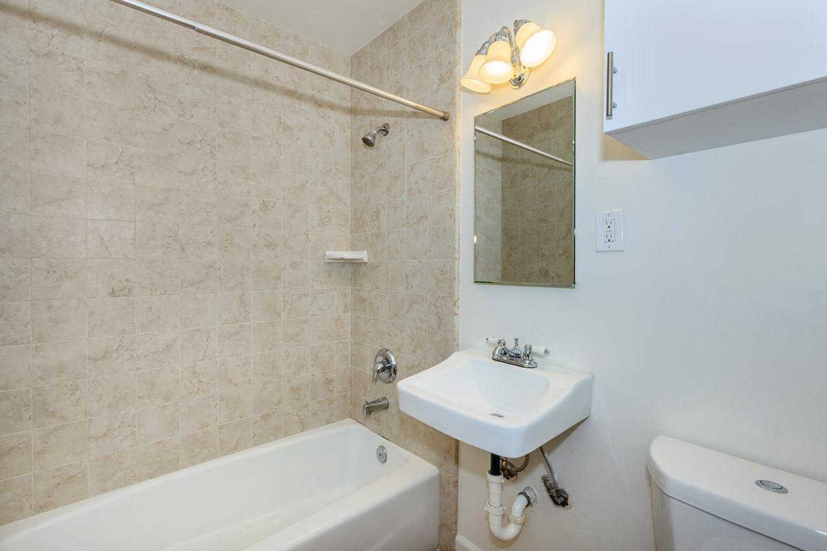 a white sink sitting under a mirror