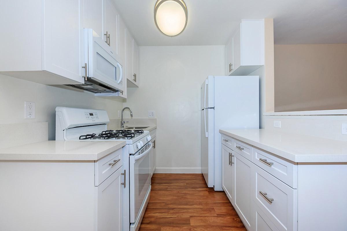 a kitchen with white appliances and wooden cabinets