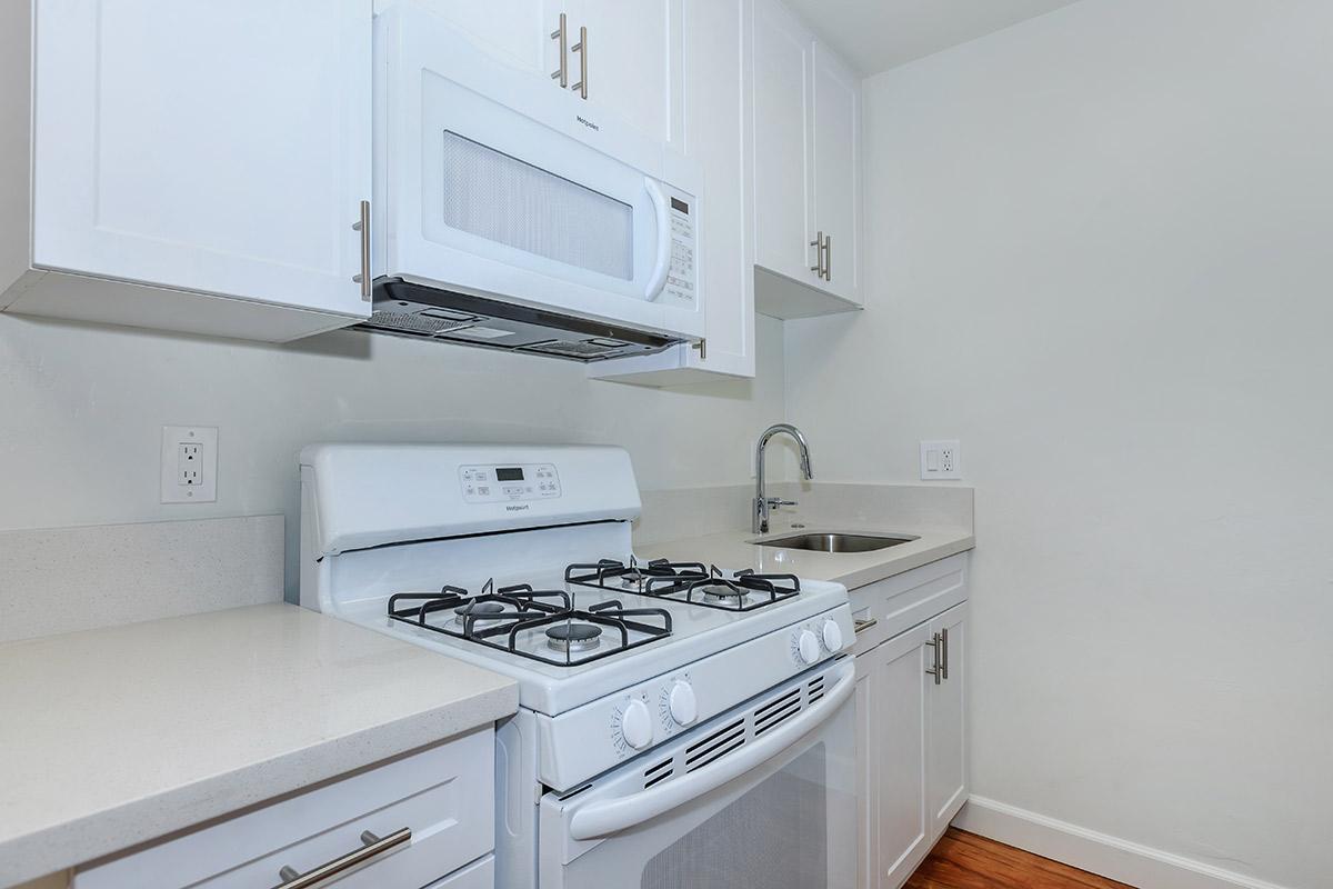 a white stove top oven sitting inside of a kitchen