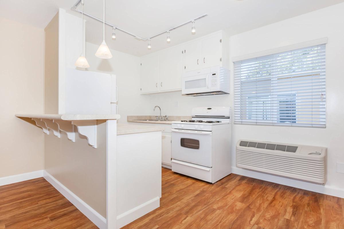 a kitchen with a stove top oven sitting inside of a hard wood floor