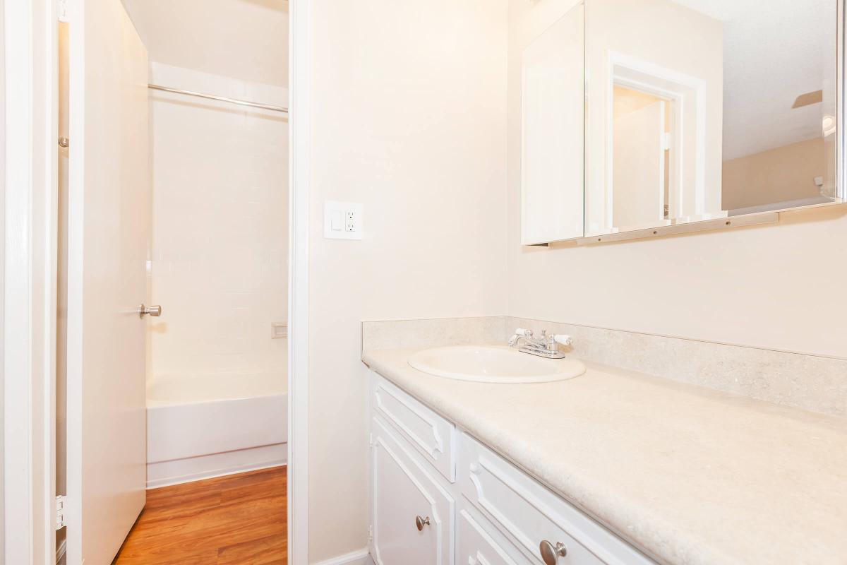 a white sink sitting next to a shower