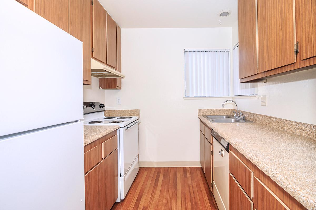 a kitchen with a stove refrigerator and wooden cabinets