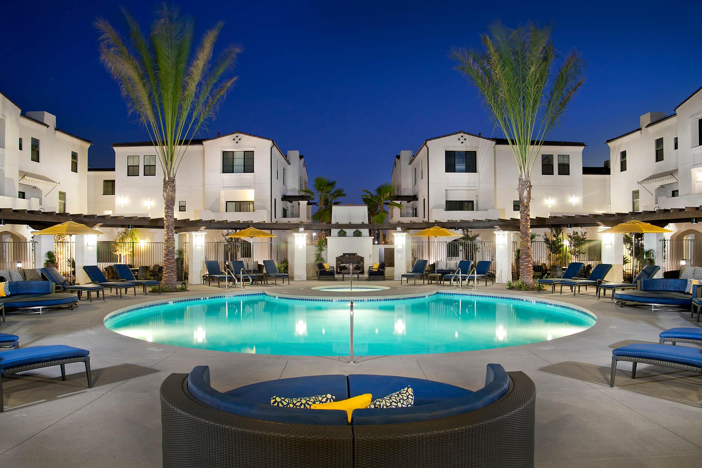 a pool in front of a building at dusk