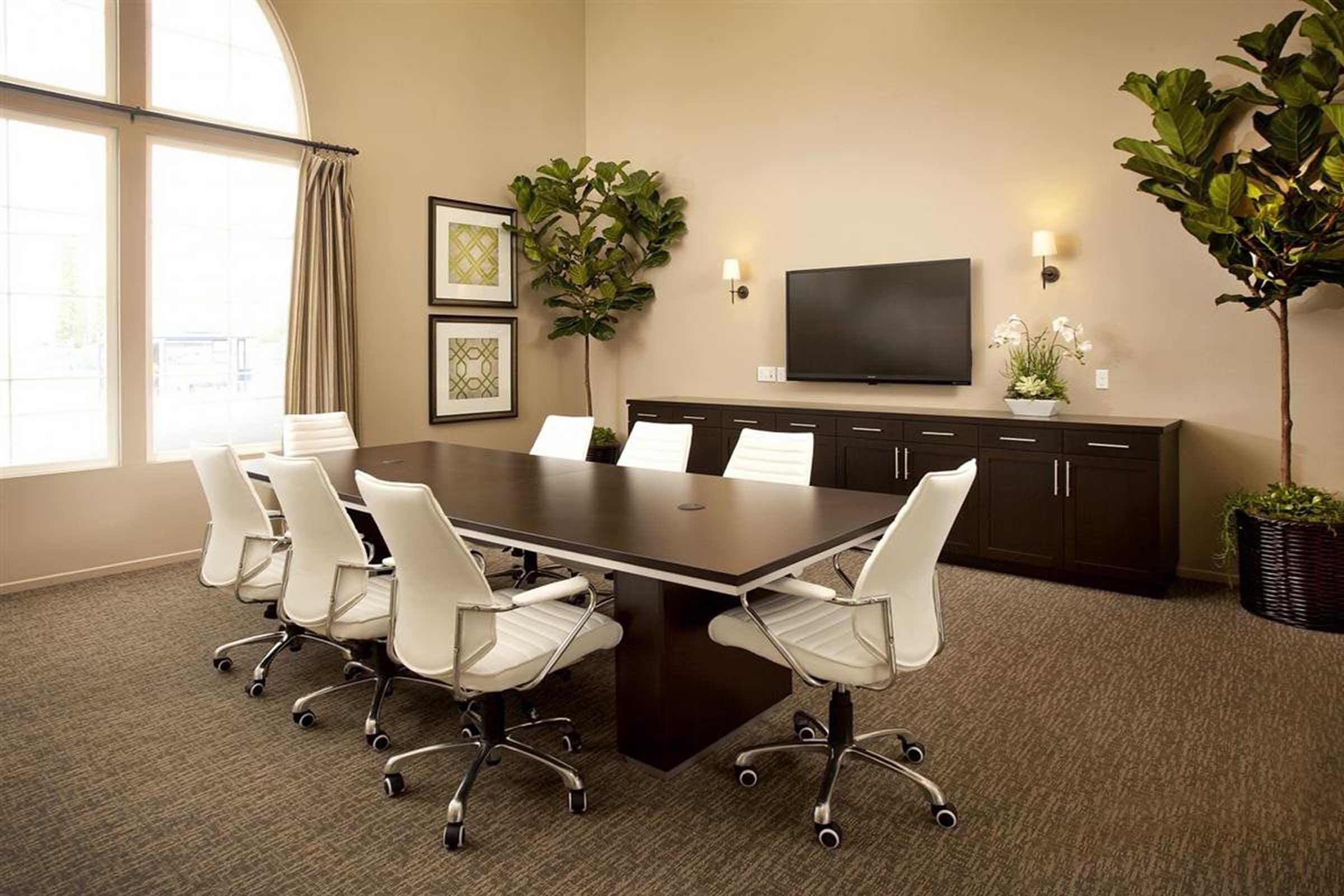 a meeting room with a large table and television