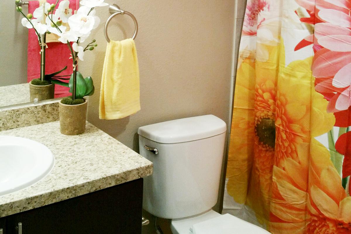 a white sink sitting under a mirror