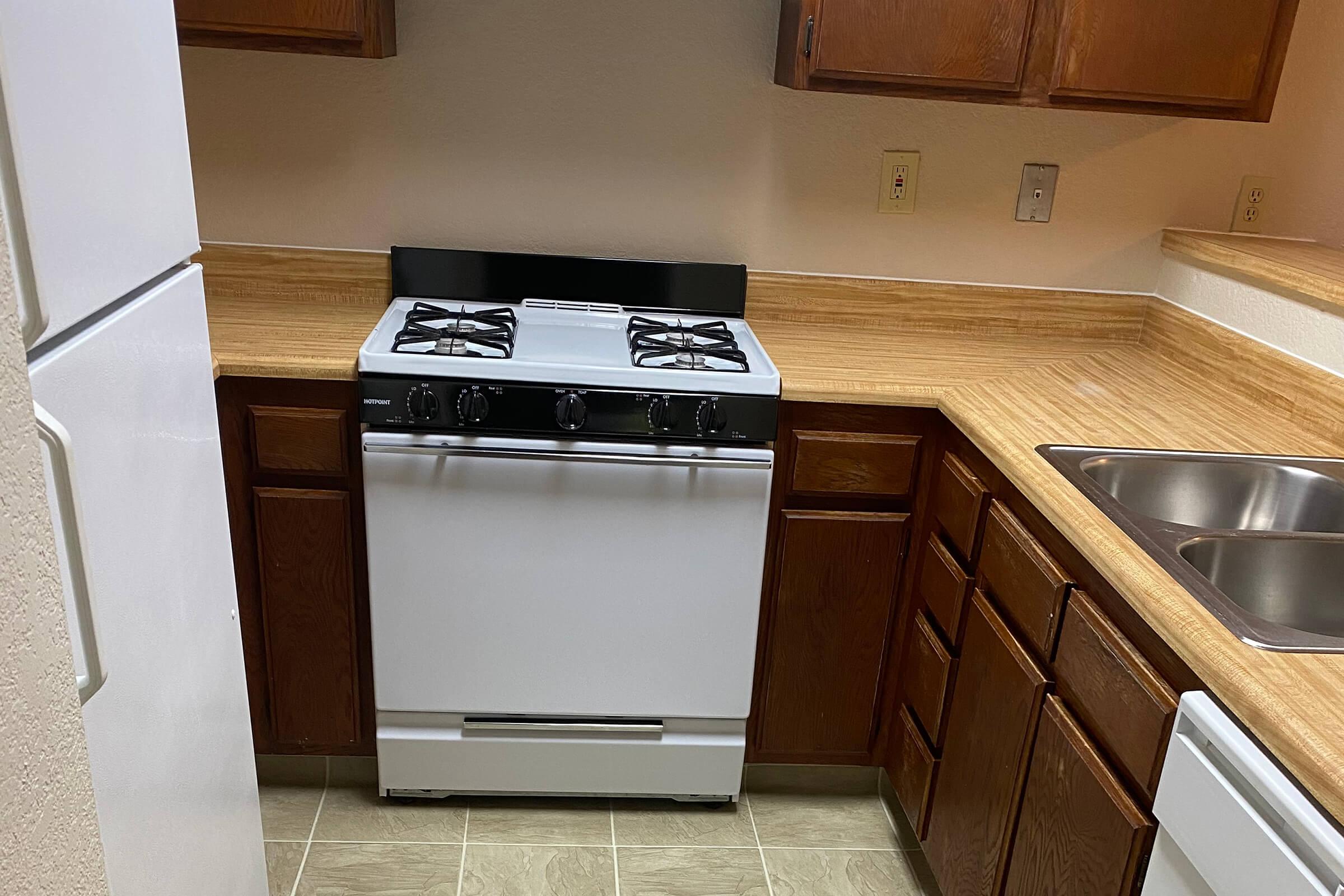 a stove top oven sitting inside of a kitchen