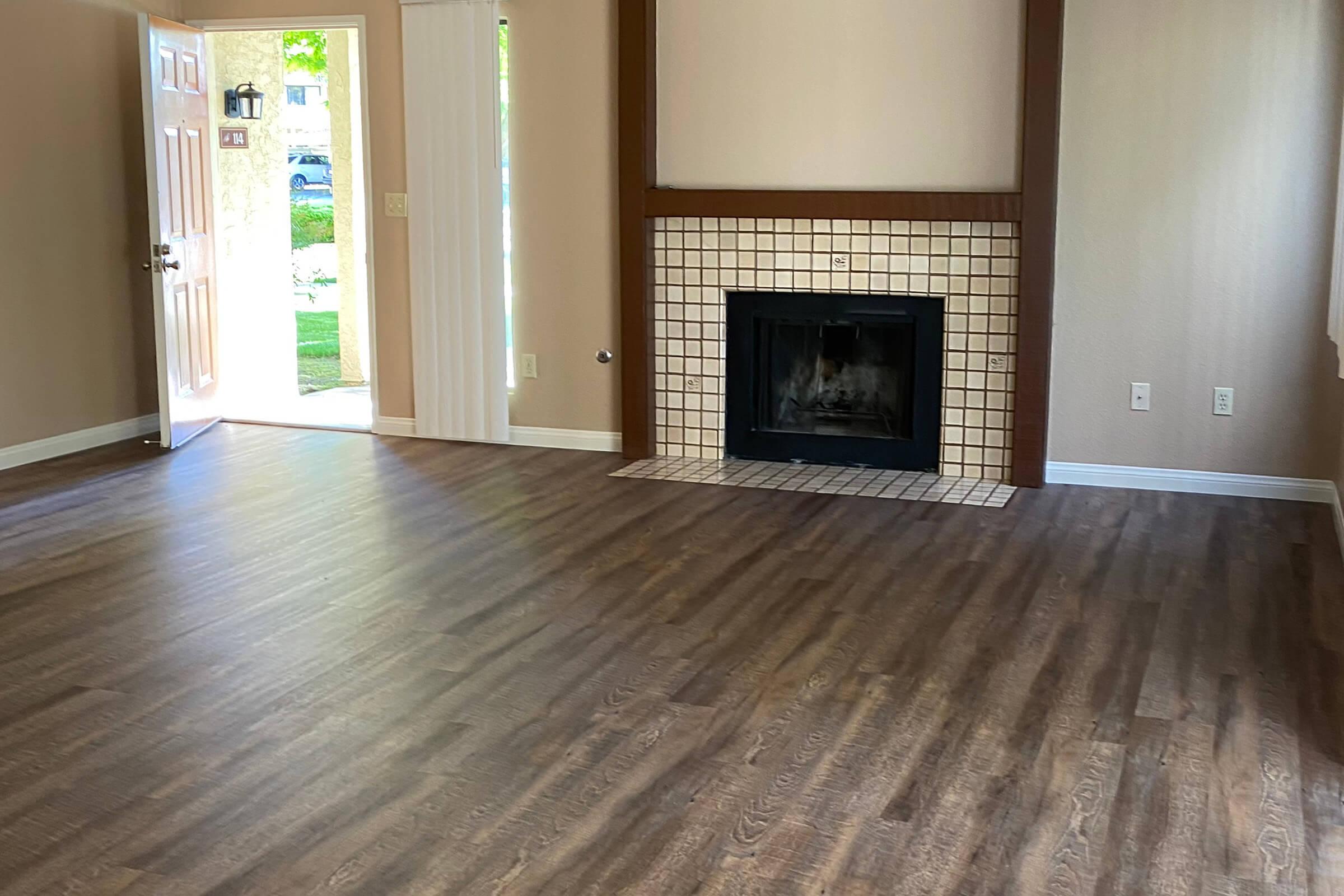 a close up of a hard wood floor next to a fireplace