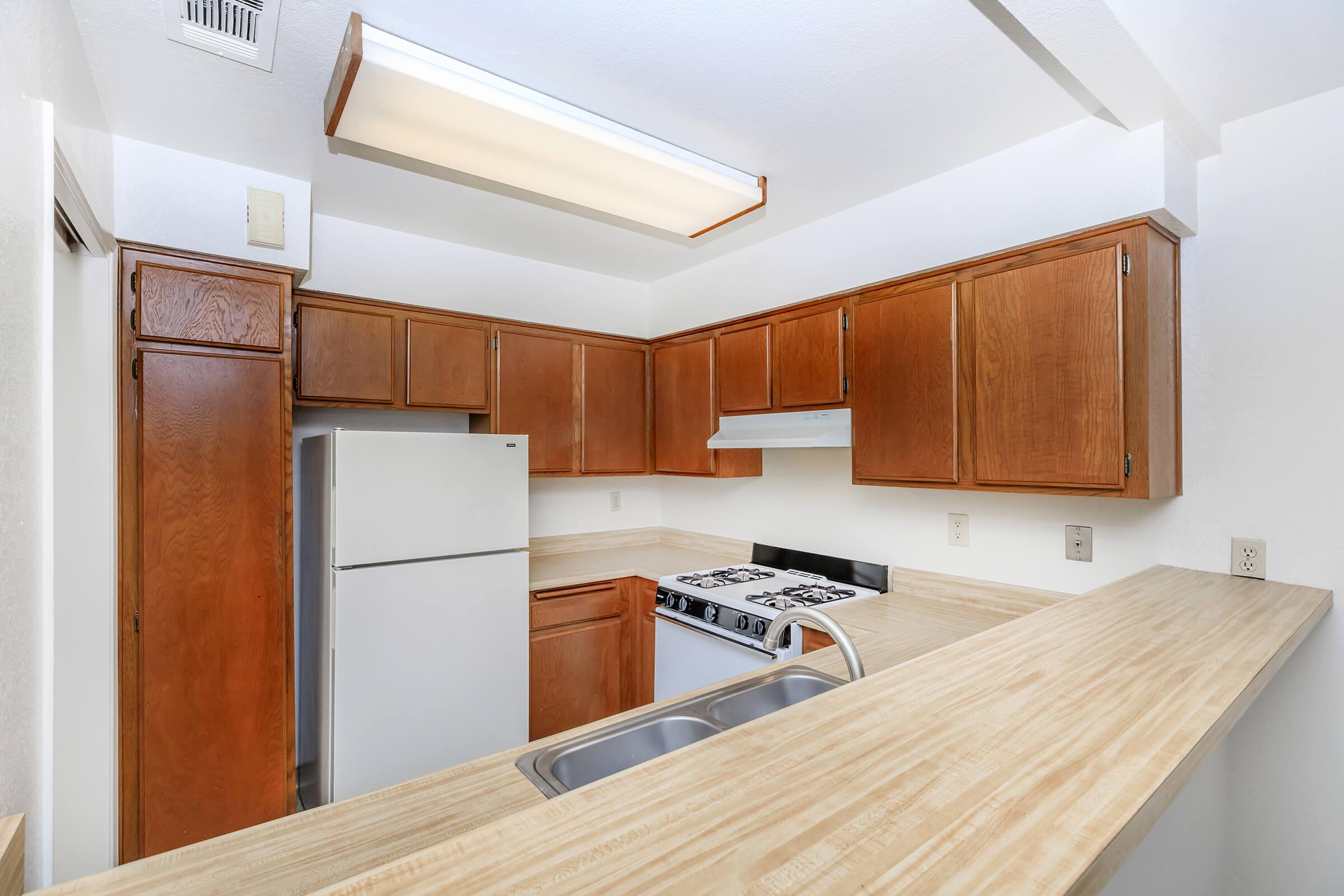 a kitchen with wooden cabinets and a refrigerator