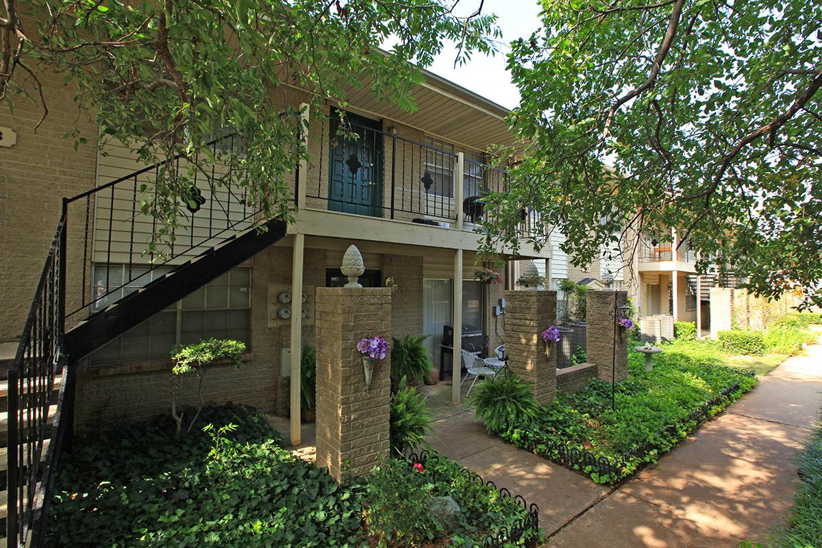 a garden in front of a brick building